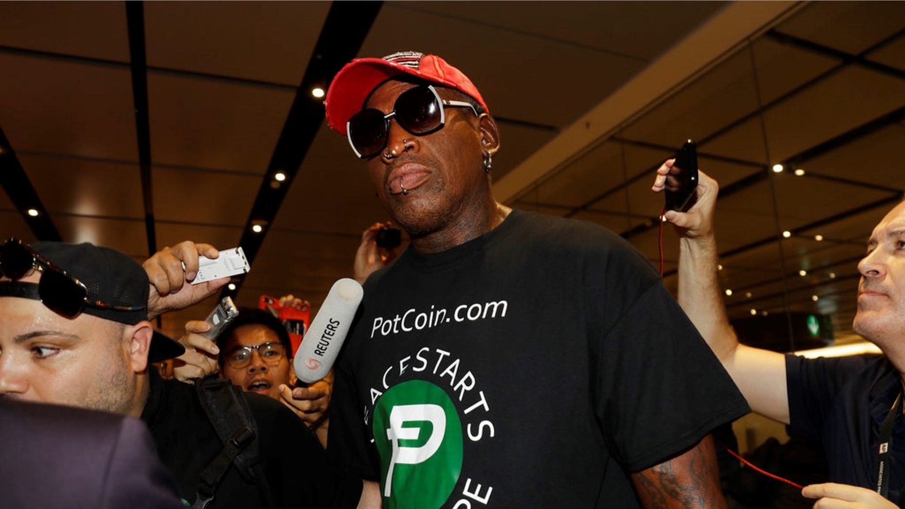 Former NBA basketball player Dennis Rodman arrives at Singapore's Changi Airport on Tuesday, June 12, 2018. (AP Photo/Wong Maye-E)