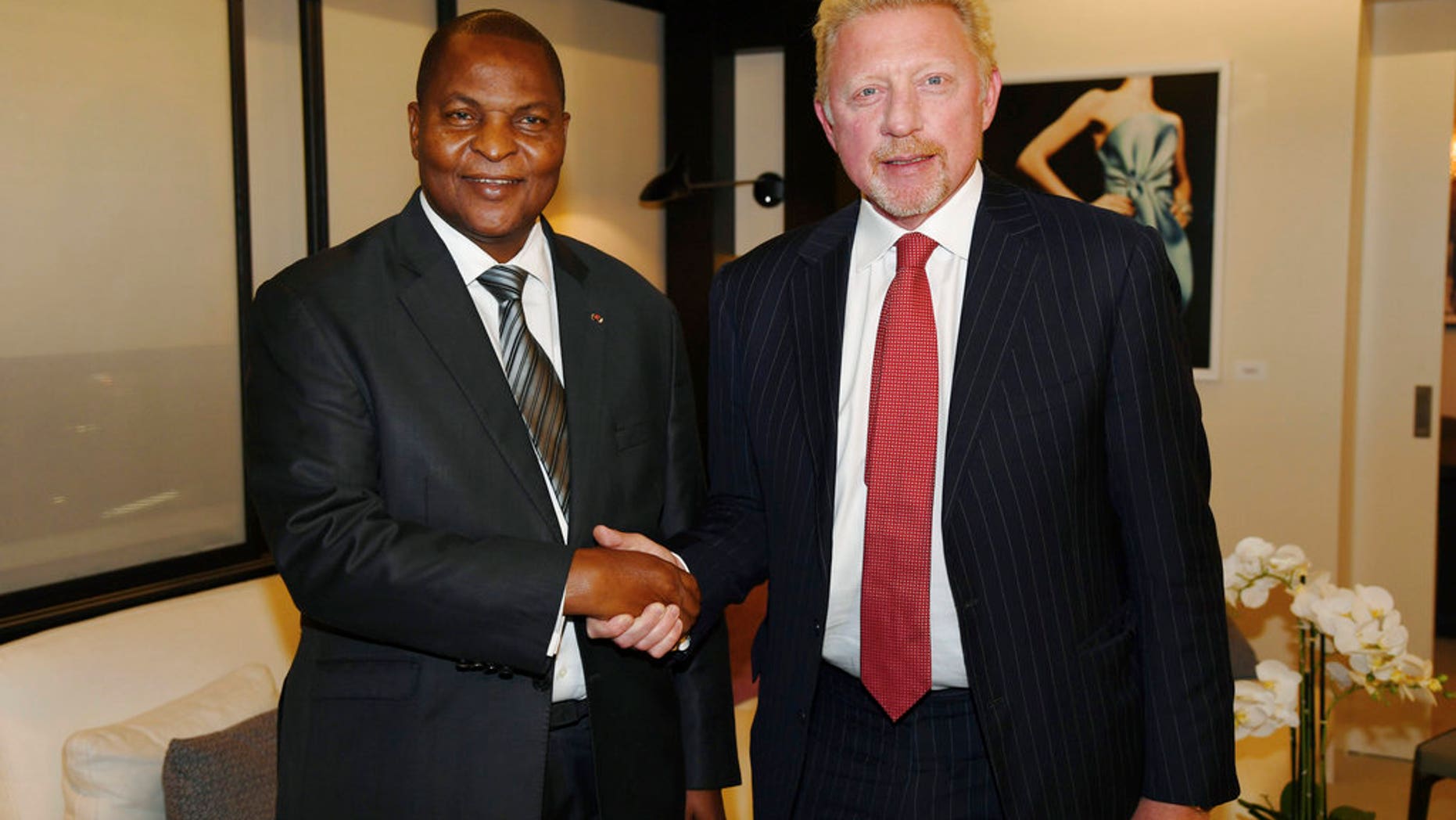 In this photo originally released on April 27, President Faustin Archange Touadera, left, shakes hands with retired tennis star Boris Becker, in Brussels, after it was announced he had been appointed by the CAR as a cultural attache