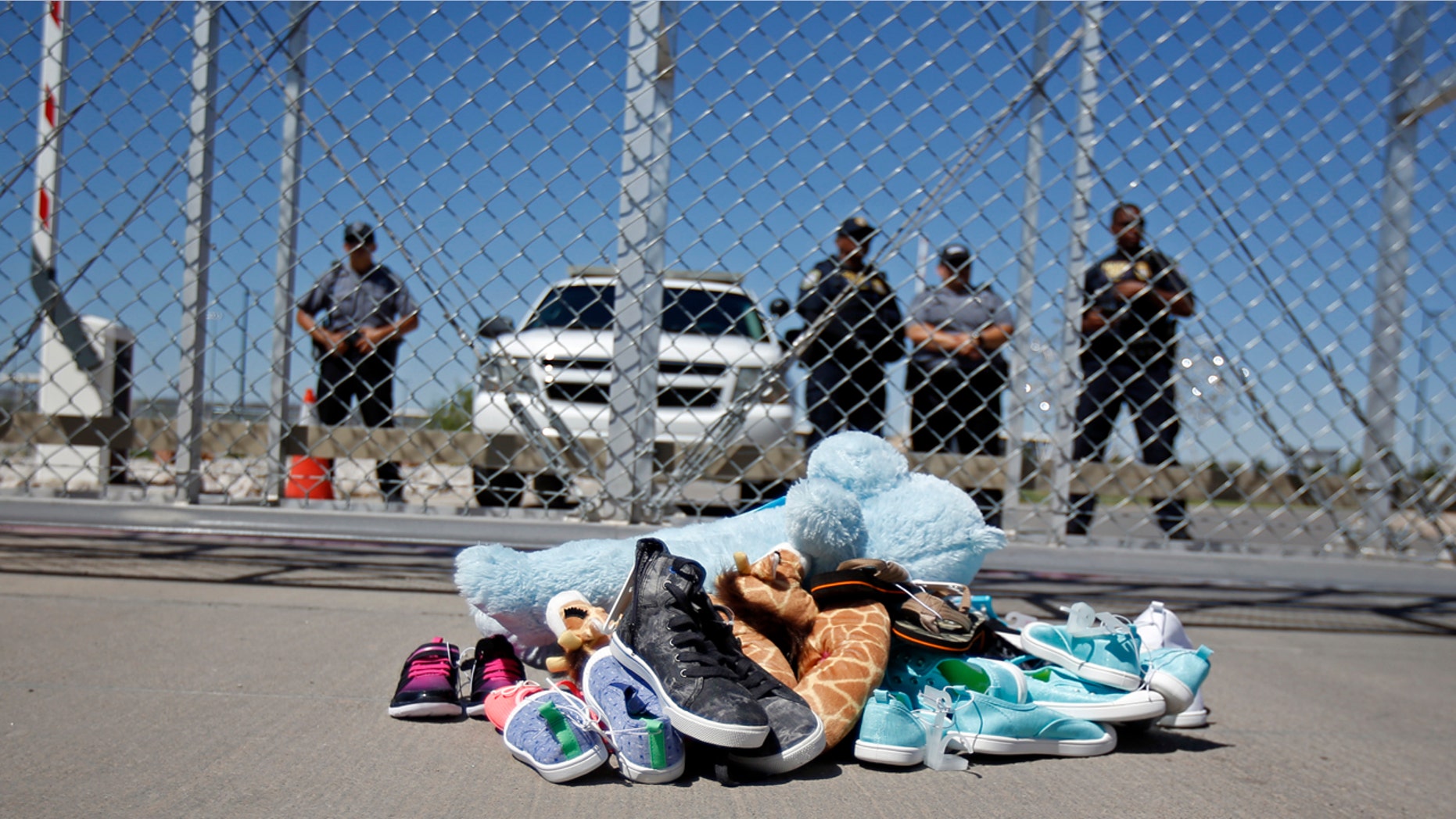Shoes and a teddy bear, brought by a group of U.S. mayors, are piled up outside a holding facility for immigrant children in Tornillo, Texas, near the Mexican border, Thursday, June 21, 2018.