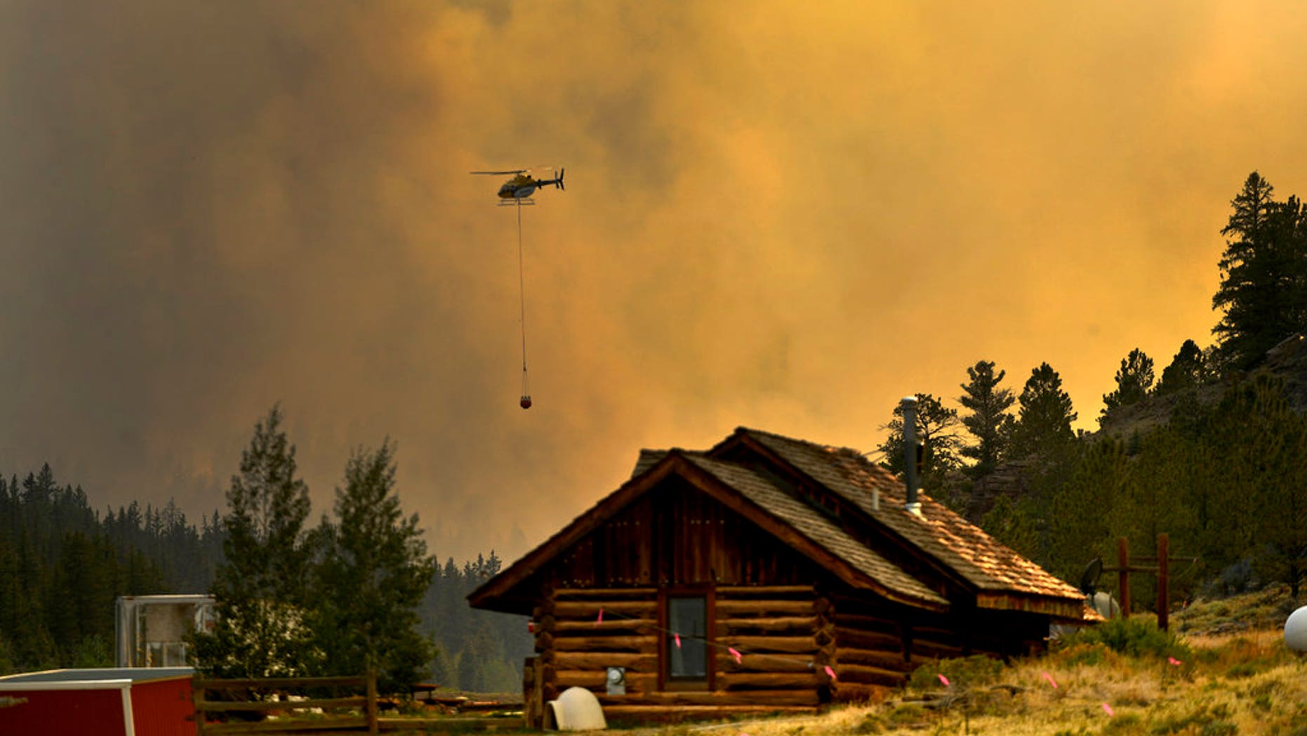 In this Monday, July 2, 2018 photo, a helicopter returns for water after making a water drop on a wildfire near Fairplay, Colorado.