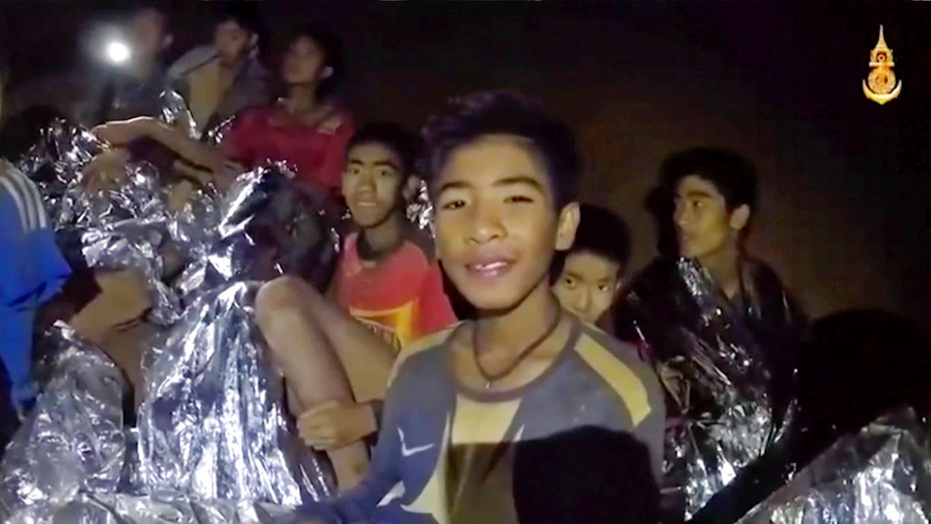Thai soccer players smile as a Thai navy SEAL medic helps injured youths inside a cave in Mae Sai, northern Thailand, July 3, 2018.