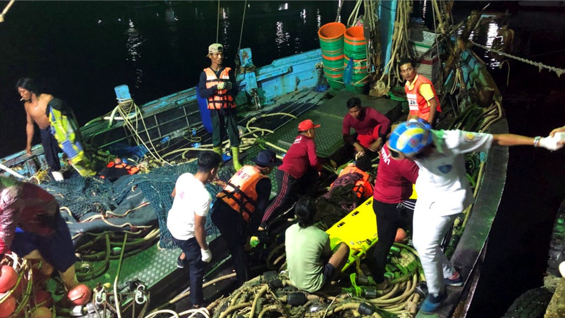 Rescued tourists from a boat that sank are helped onto a pier from a fishing boat Thursday, July 5, 2018, on the island of Phuket, southern Thailand.