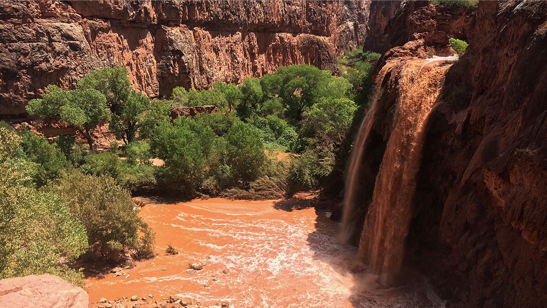 Waterfalls normally blue-green turned muddy brown in Supai, Ariz., after flooding the area, July 11, 2018.