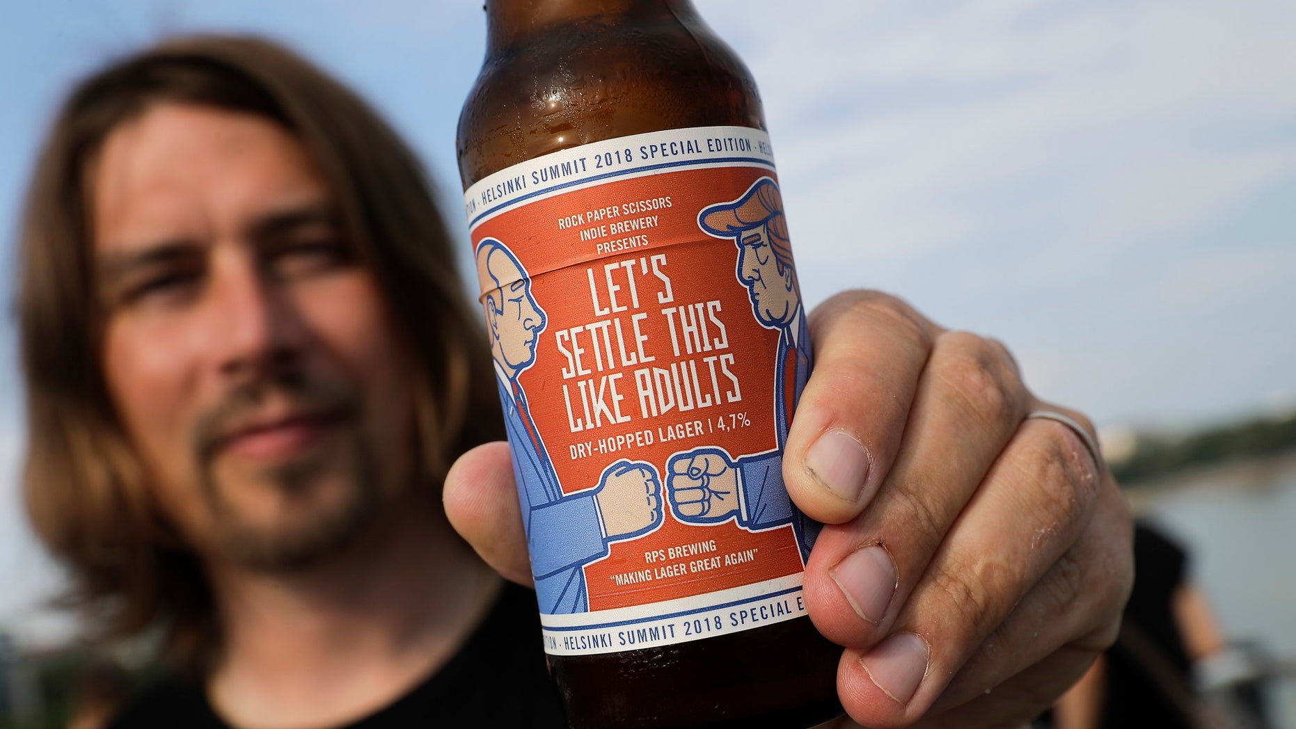 Samuli Huuhtanen, CEO of Finnish brewery Rock Paper Scissors, displays a bottle of "Let's Settle this Like Adults," a beer inspired by Monday's scheduled Trump-Putin summit.