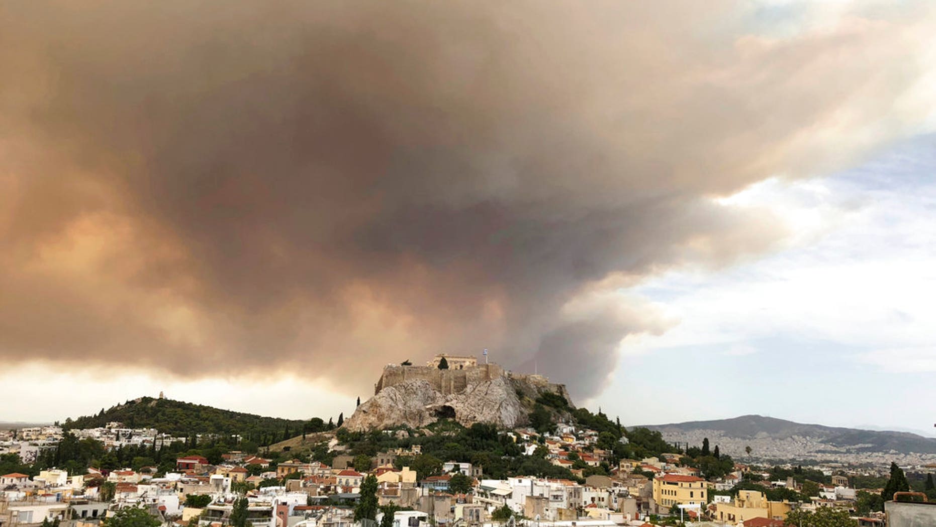 At least 20 people have been killed and dozens more injured as two huge wildfires burned outside of Athens, Greece, officials announced Tuesday.