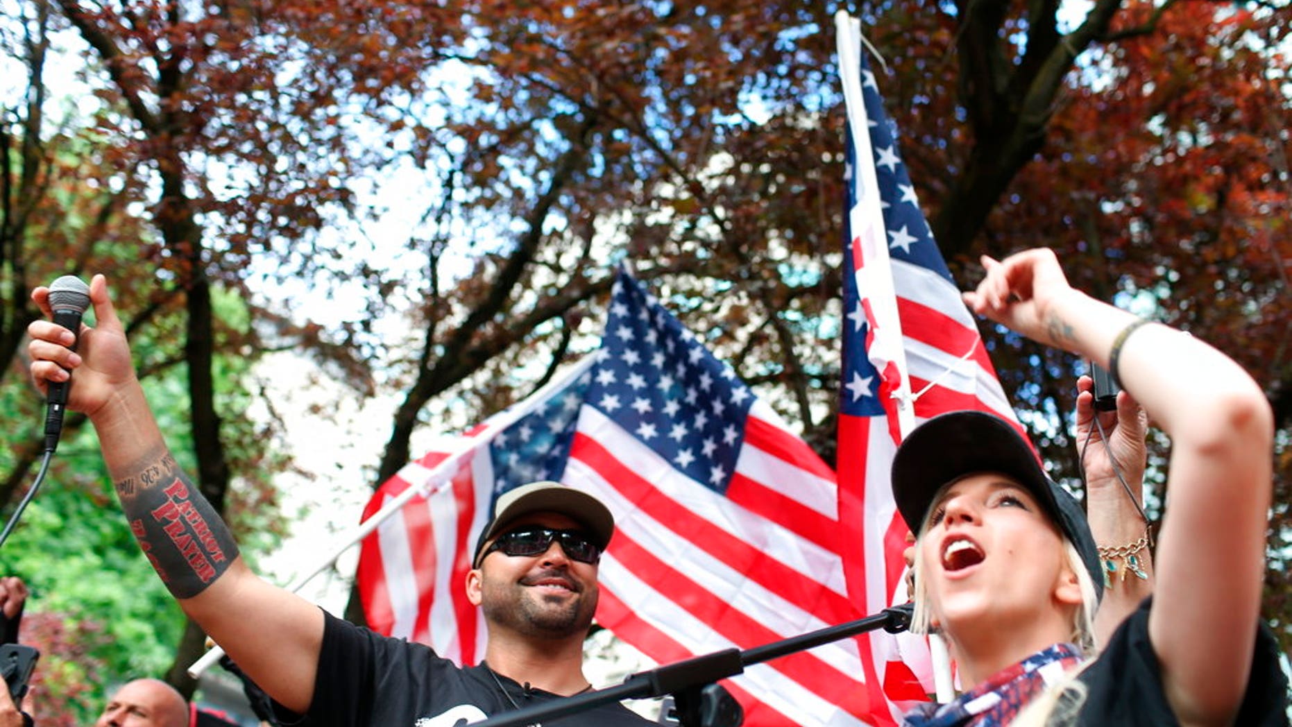 FILE--In this June 30, 2018, file photo, Joey Gibson, left, leader of Patriot Prayer, heads the group's rally in Portland, Ore. Portland is bracing for what could be another round of violent clashes Saturday, Aug. 4, 2018, between a right-wing group holding a rally here and self-described anti-fascist counter-protesters who have pledged to keep Patriot Prayer and other affiliated groups out of this ultra-liberal city. (Mark Graves/The Oregonian via AP, file)