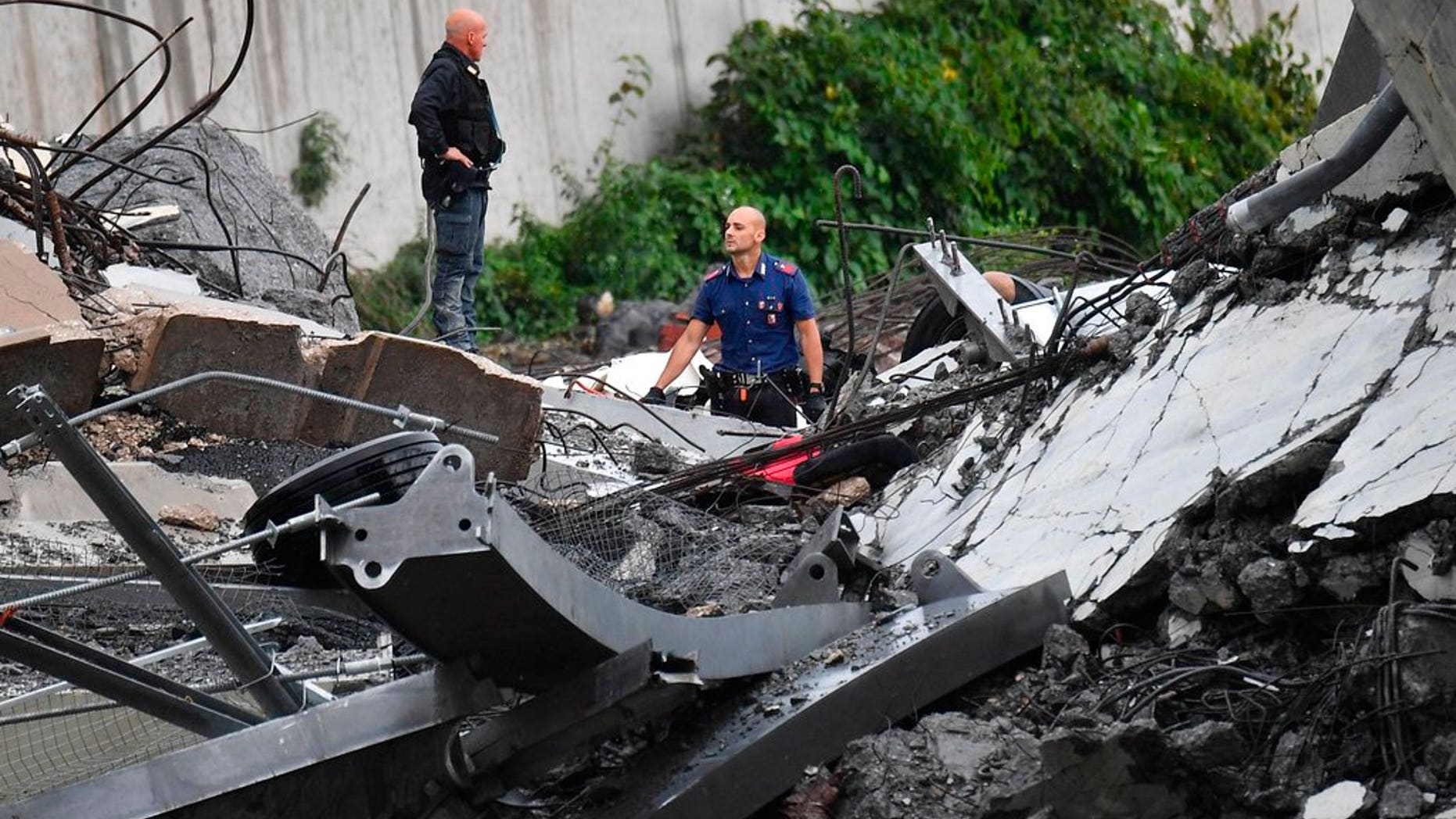 Rescues work among the debris of the collapsed Morandi highway bridge in Genoa, Tuesday, Aug. 14, 2018. Italian authorities say that about 10 vehicles were involved when the raised highway collapsed during a sudden and violent storm in the northern port city of Genoa, while private broadcaster Sky TG24 said the collapsed section was about 200-meter long (650 feet). (Luca Zennaro/ANSA via AP)