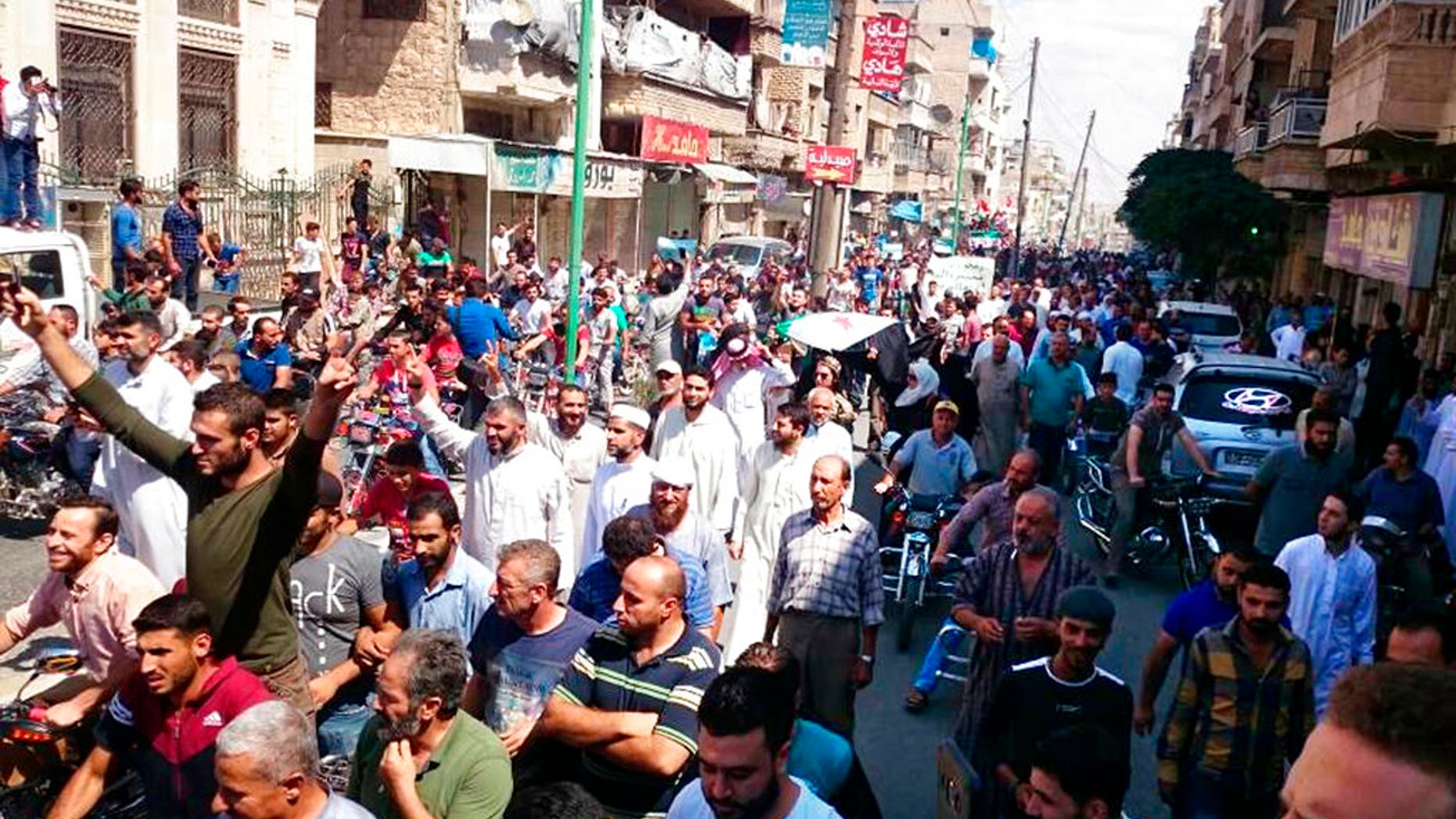 Protesters holding Syrian revolution flags and chanting, in Maaret al-Numan, a town in Idlib province, Syria, Friday, Sept 7, 2018; The Friday rallies came as Presidents of Iran, Turkey and Russia are meeting in Tehran to discuss the war in Syria