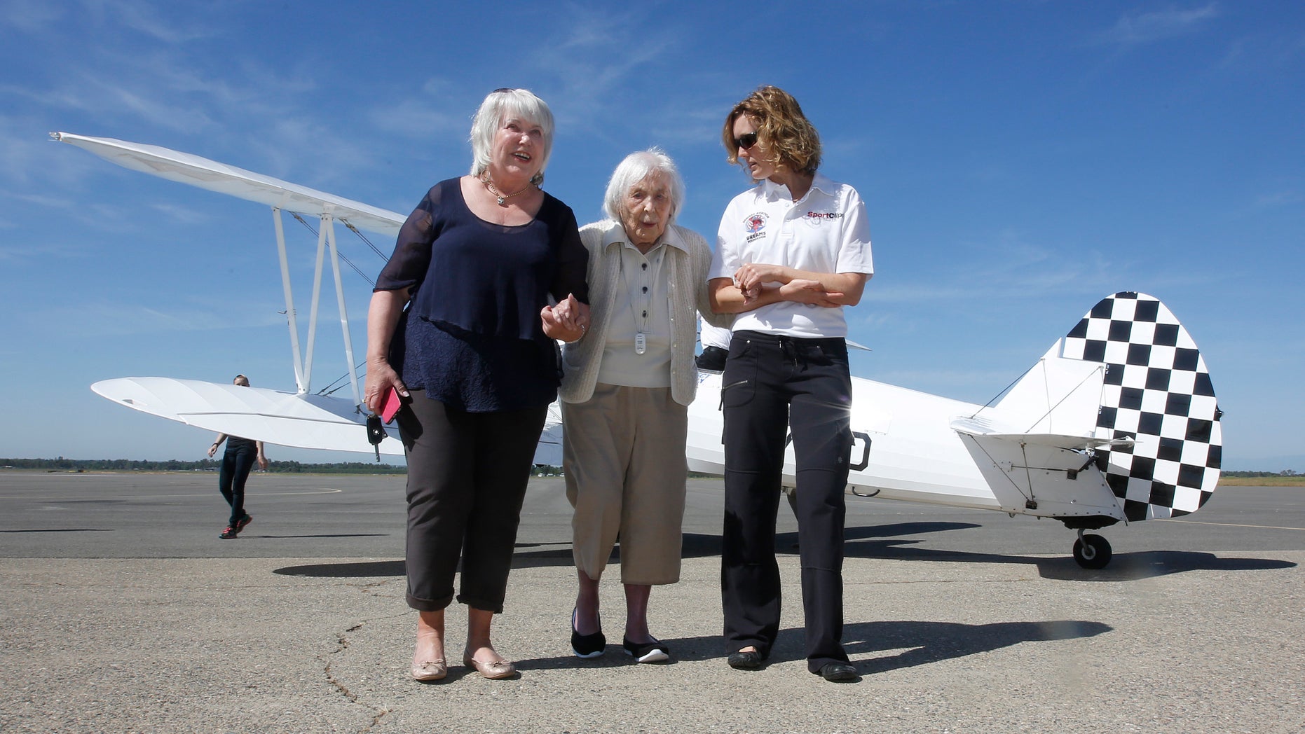 Lynn Balmer, center, escorted across the tarmac.