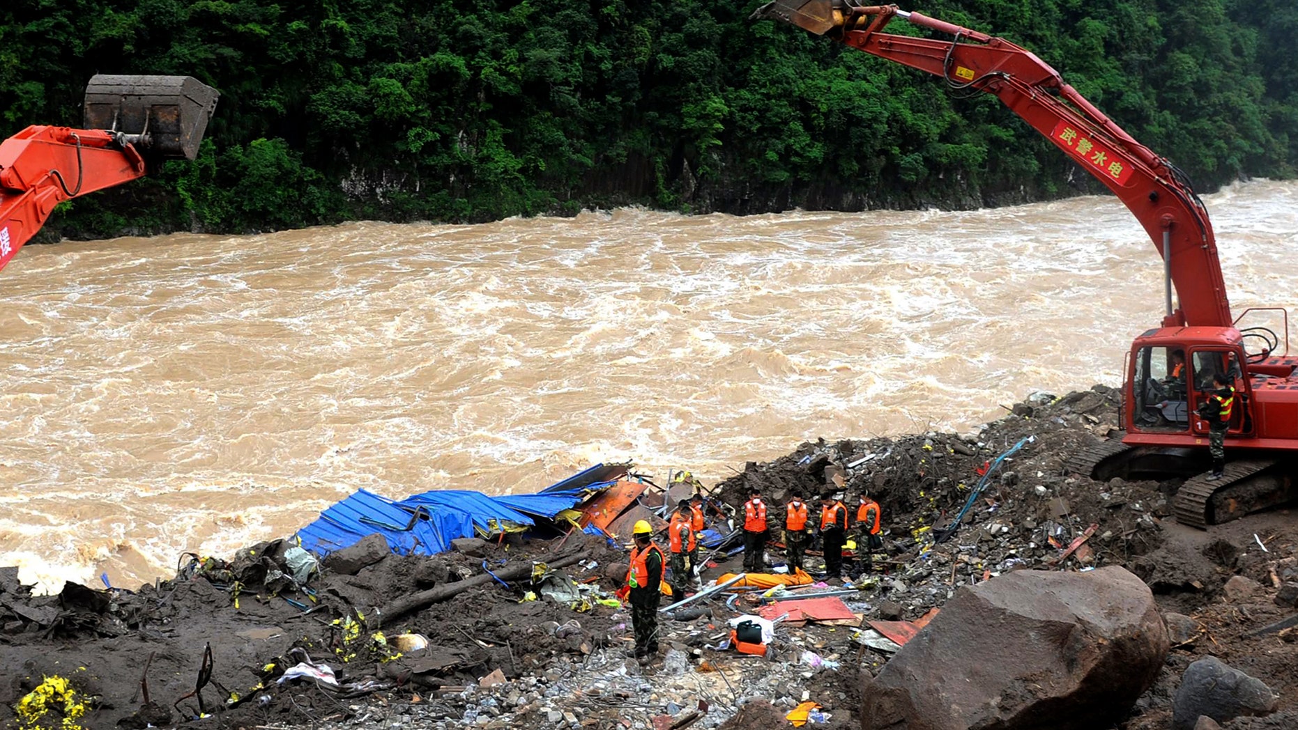 Rescuers pay respects to the body of a landslide victim in southeast China's Fujian province Monday.