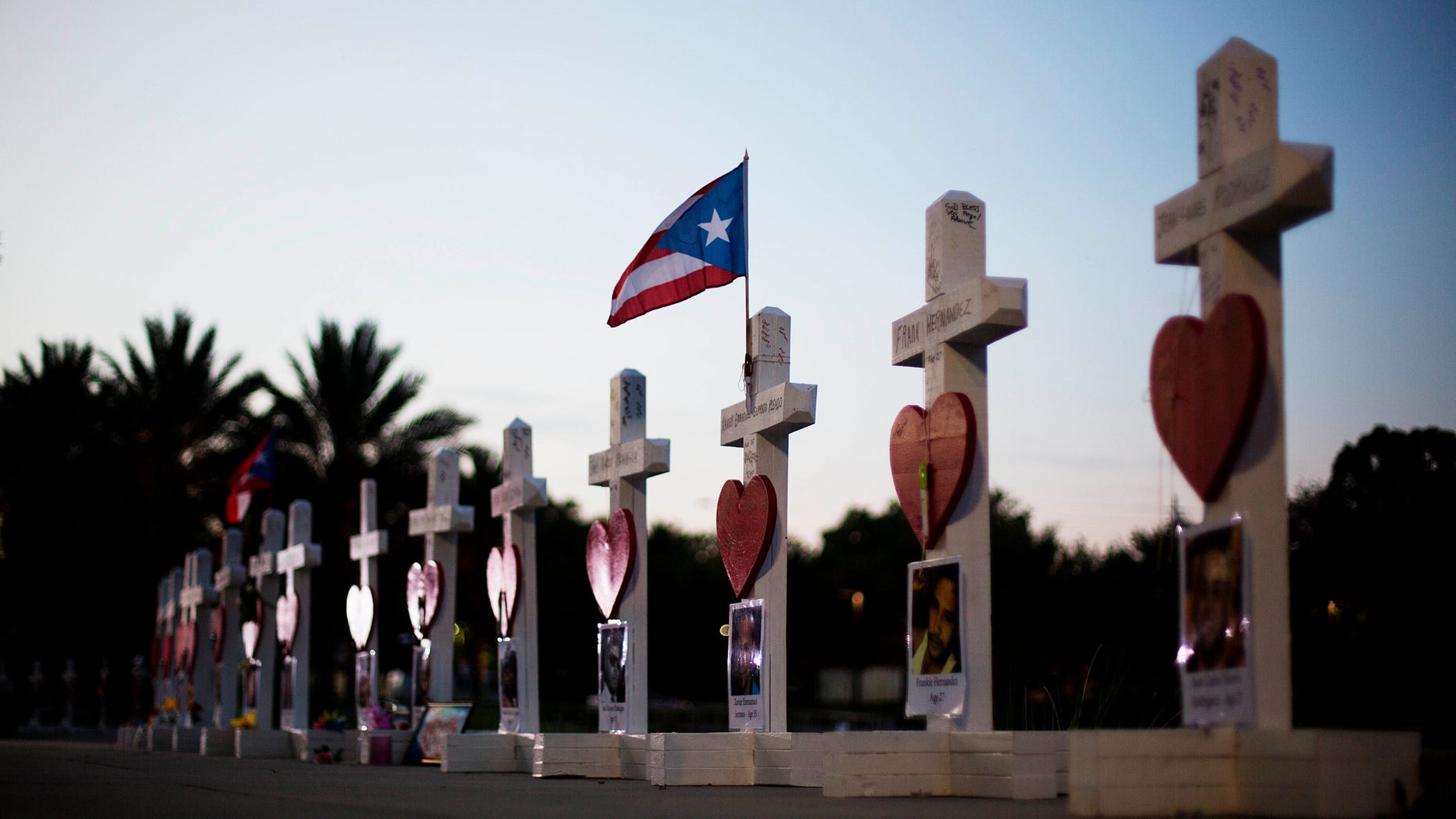 Crosses, one for each victim, line a walkway as a memorial to those killed in the Pulse nightclub mass shooting a few blocks from the club early Friday, June 17, 2016, in Orlando, Fla. (AP Photo/David Goldman)