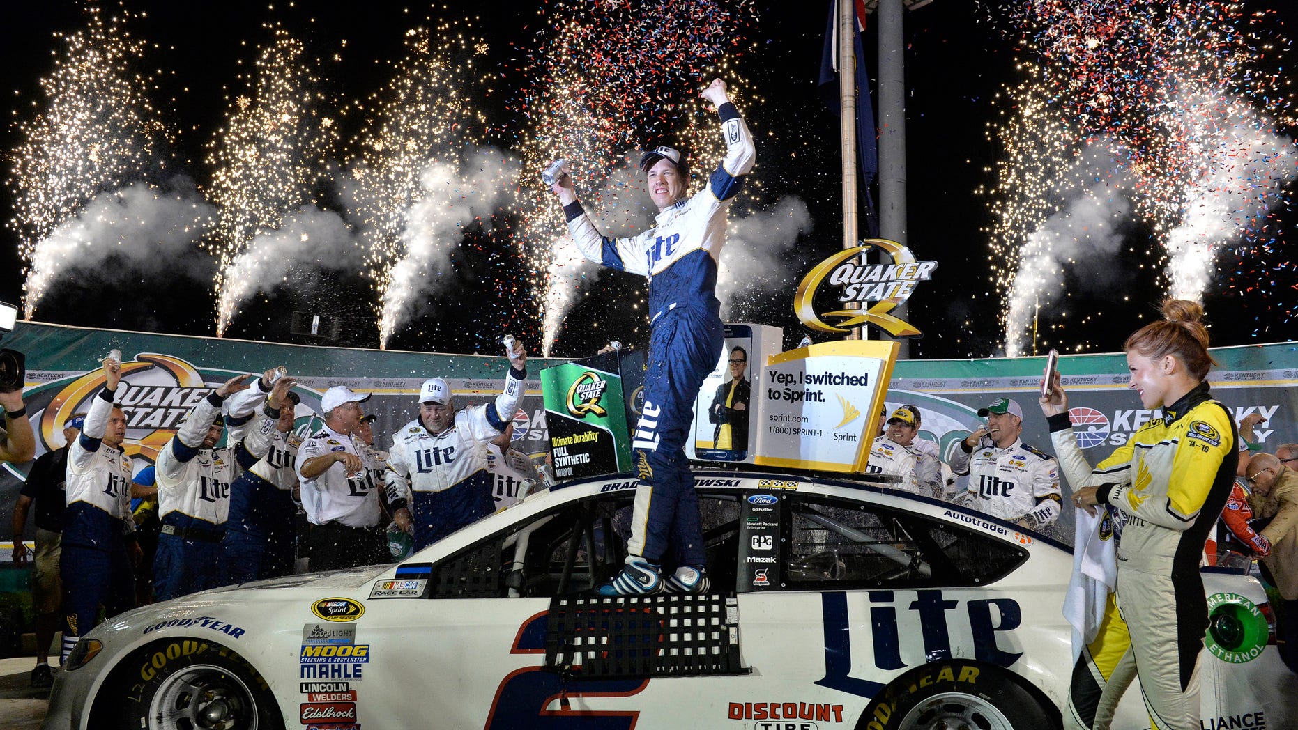 Brad Keselowski stands on his car in Victory Lane after his win in the NASCAR Sprint Cup Series auto race at Kentucky Speedway, Saturday, July 9, 2016 in Sparta, Ky. (AP Photo/Timothy D. Easley)