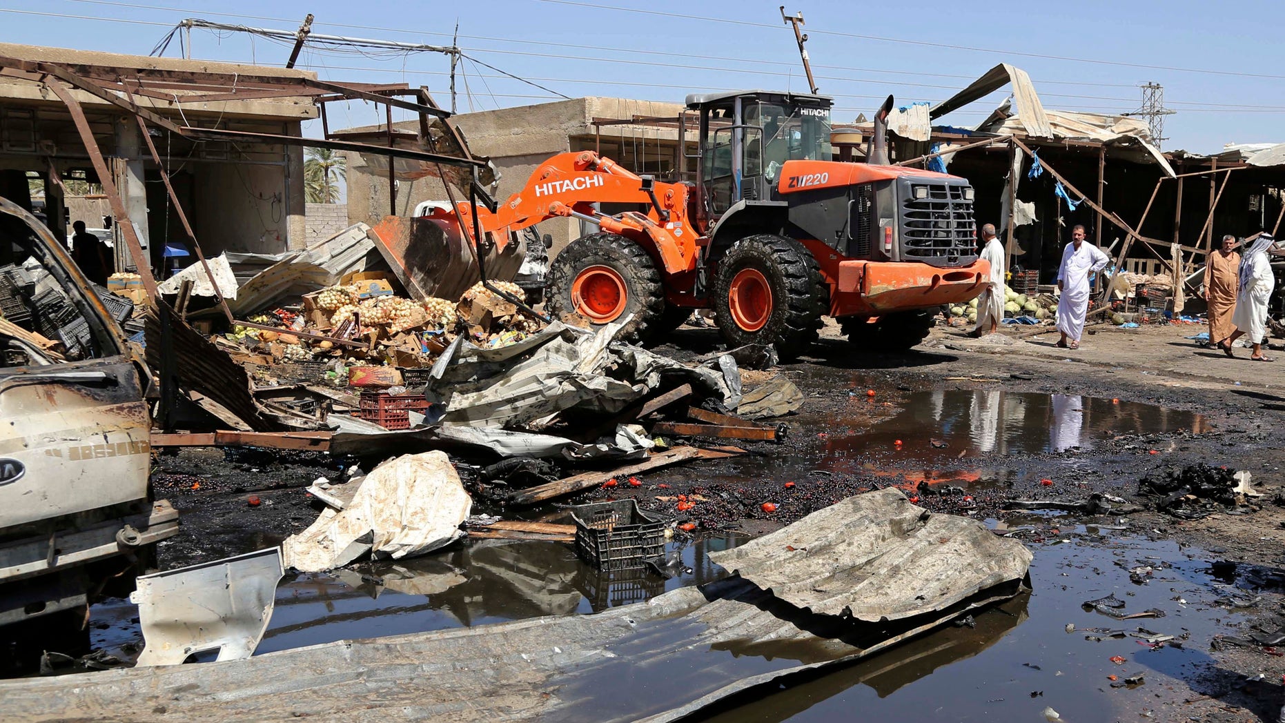 A bulldozer clears the scene of the suicide car bombing.