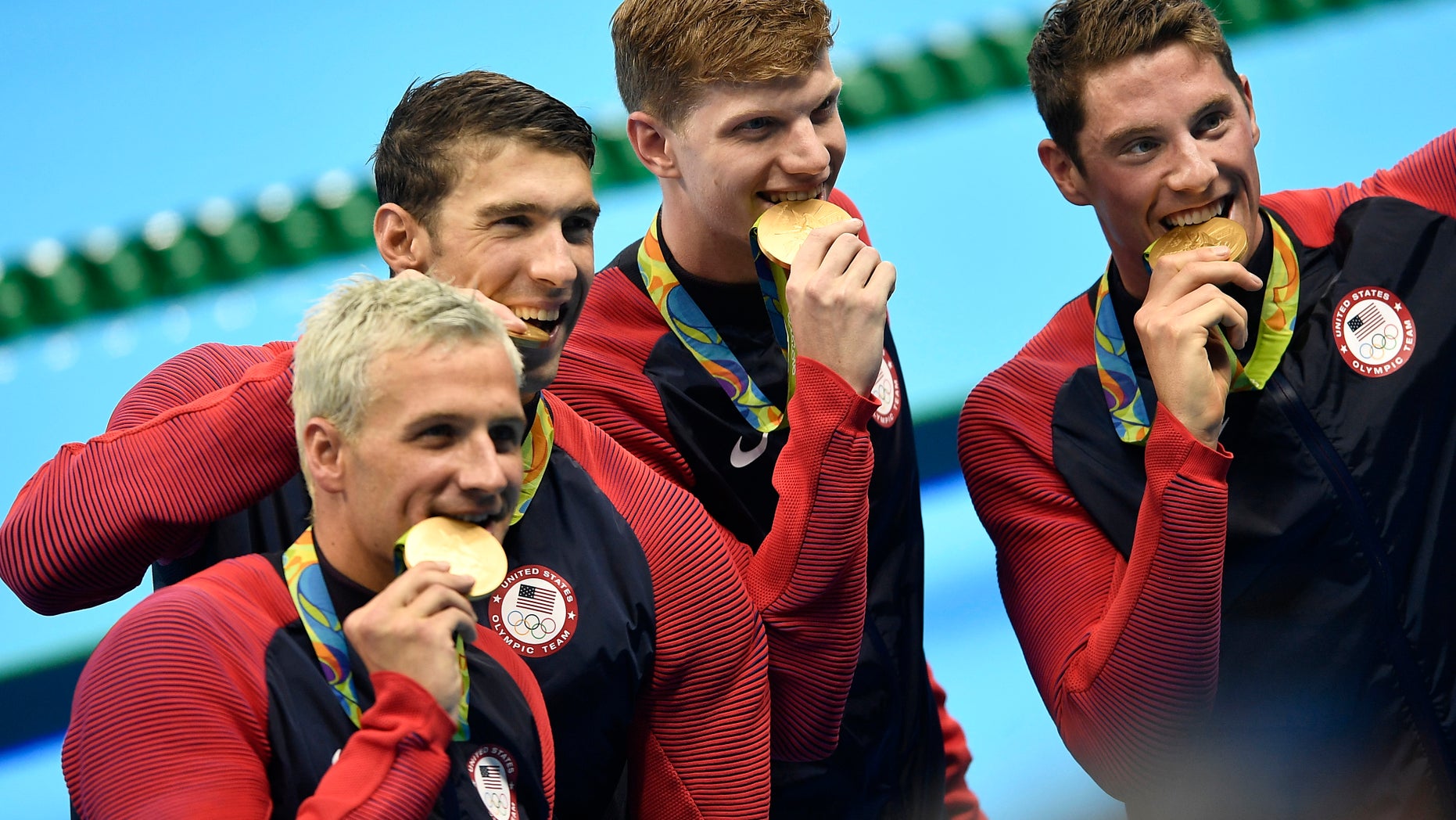 From left, Ryan Lochte, Michael Phelps, Towny Haas and Conor Dwyer from the United States bite their gold medals after the ceremony for the men's 4x200-meter freestyle final.
