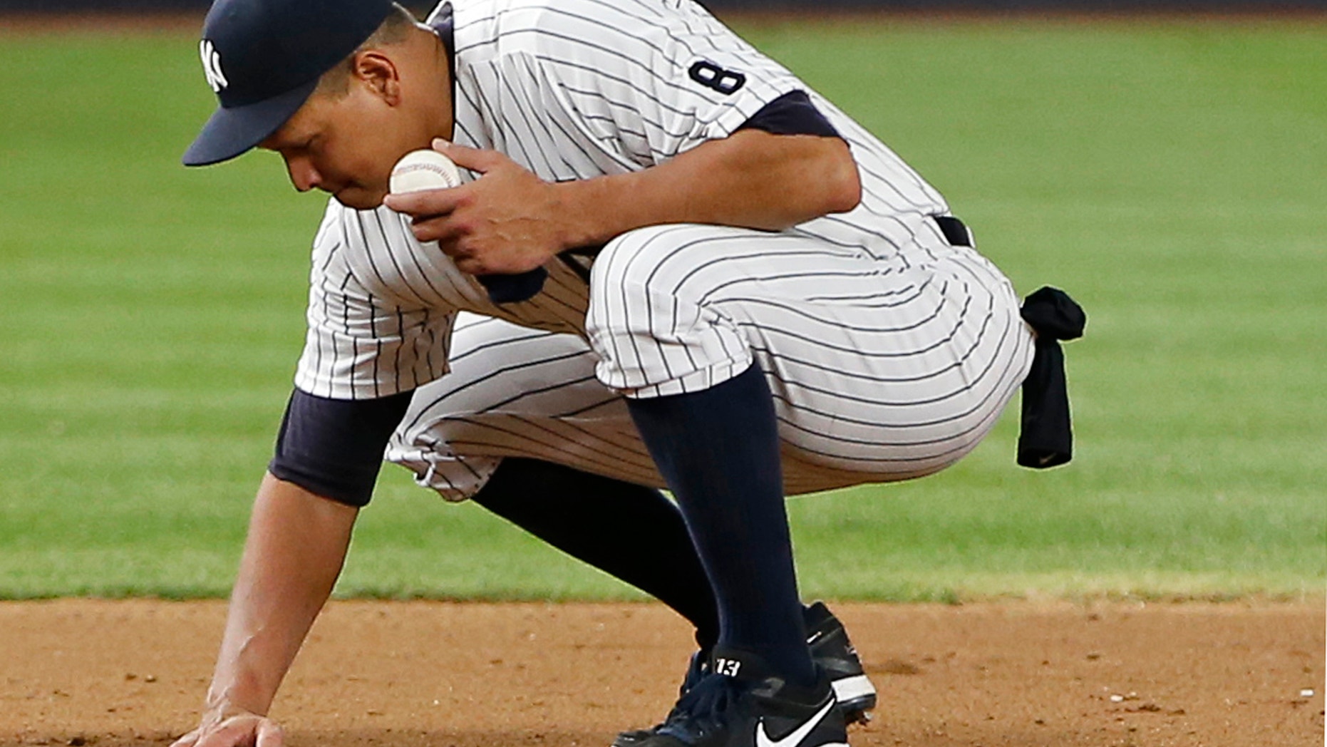 Alex Rodriguez gathers dirt from the field near third base in his final game as a Yankee.