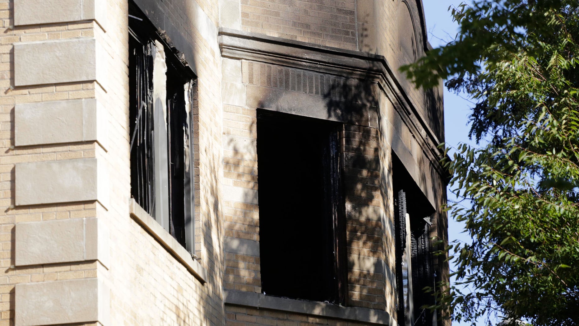 Charred and broken widows can be seen on the third floor of the apartment building after the fire.