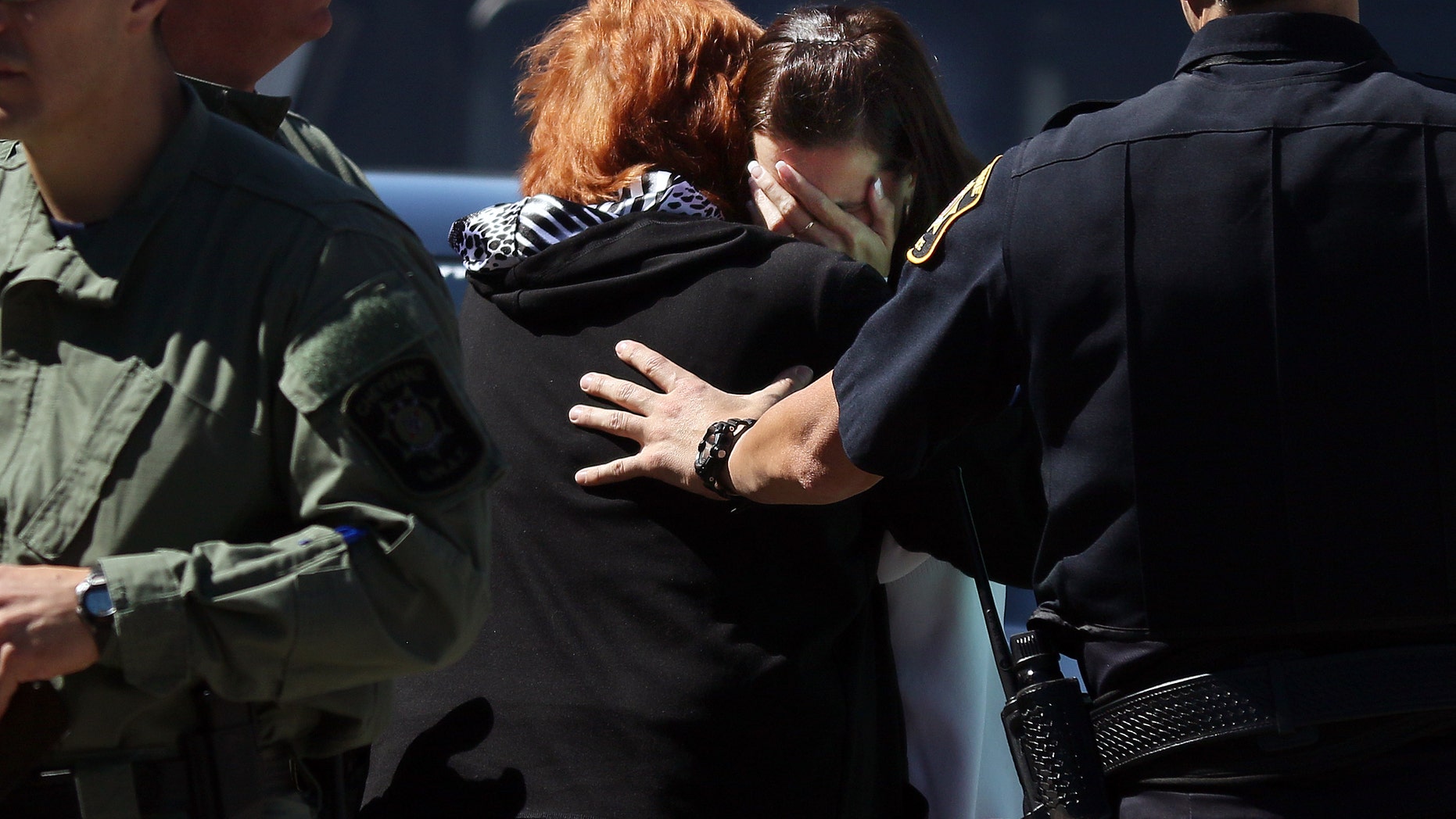 Two women grieve after hearing news of the shooting at Heritage Court Apartments Wednesday.