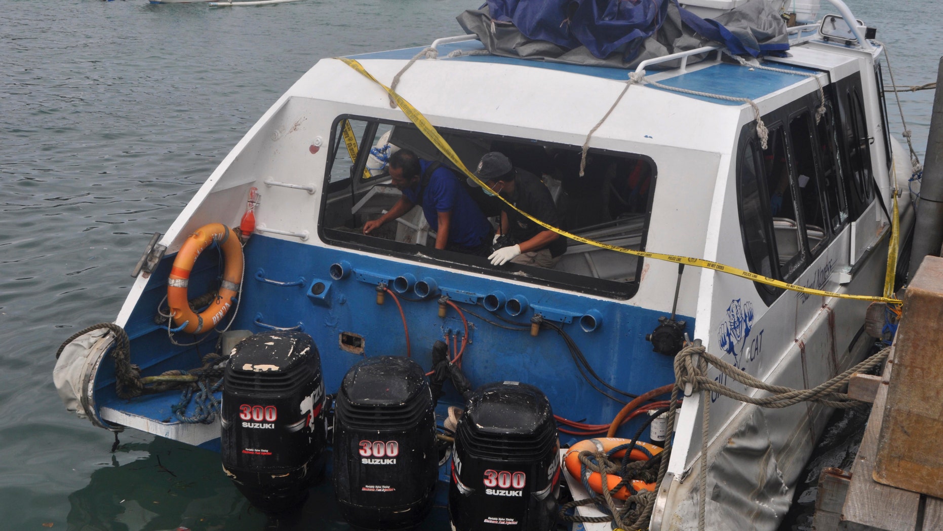 Police investigators examine the boat after the explosion.