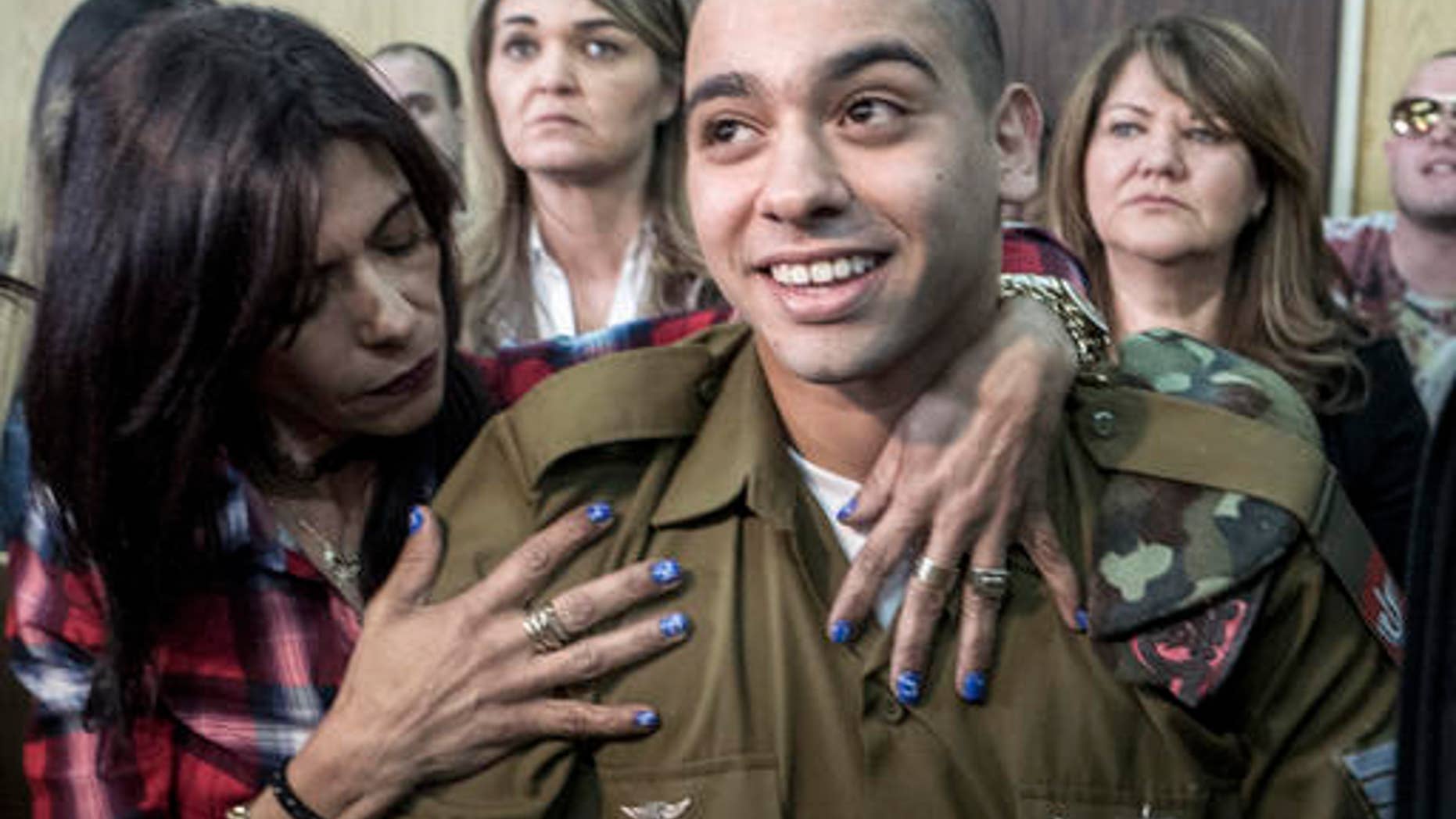 Elor Azaria embraced by his mother at the start of his sentencing hearing.