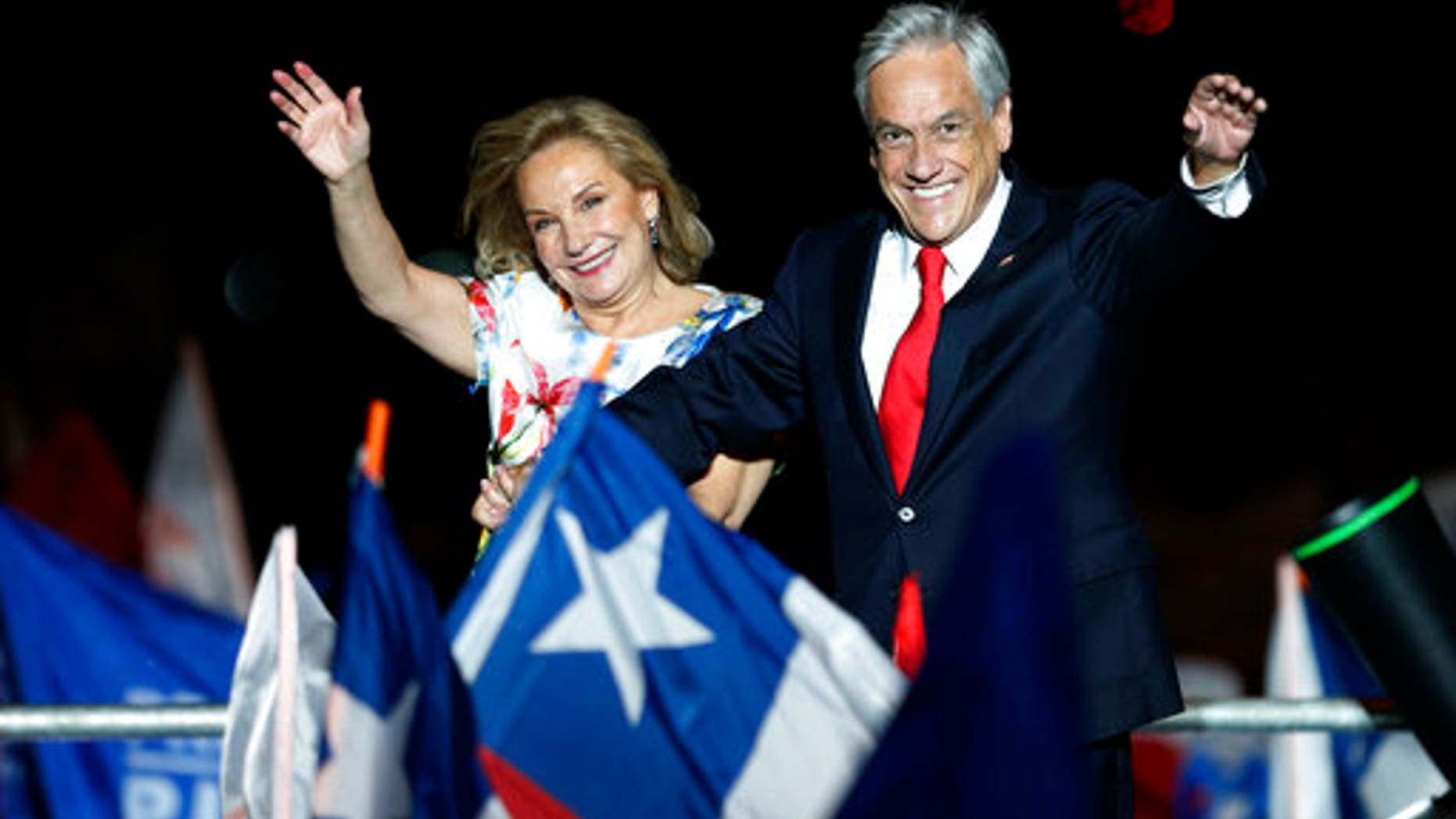 Chile's former President Sebastian Pinera and his wife Cecilia Morel wave to supporters as they celebrate Pinera's winning the presidential election runoff in Santiago, Chile.