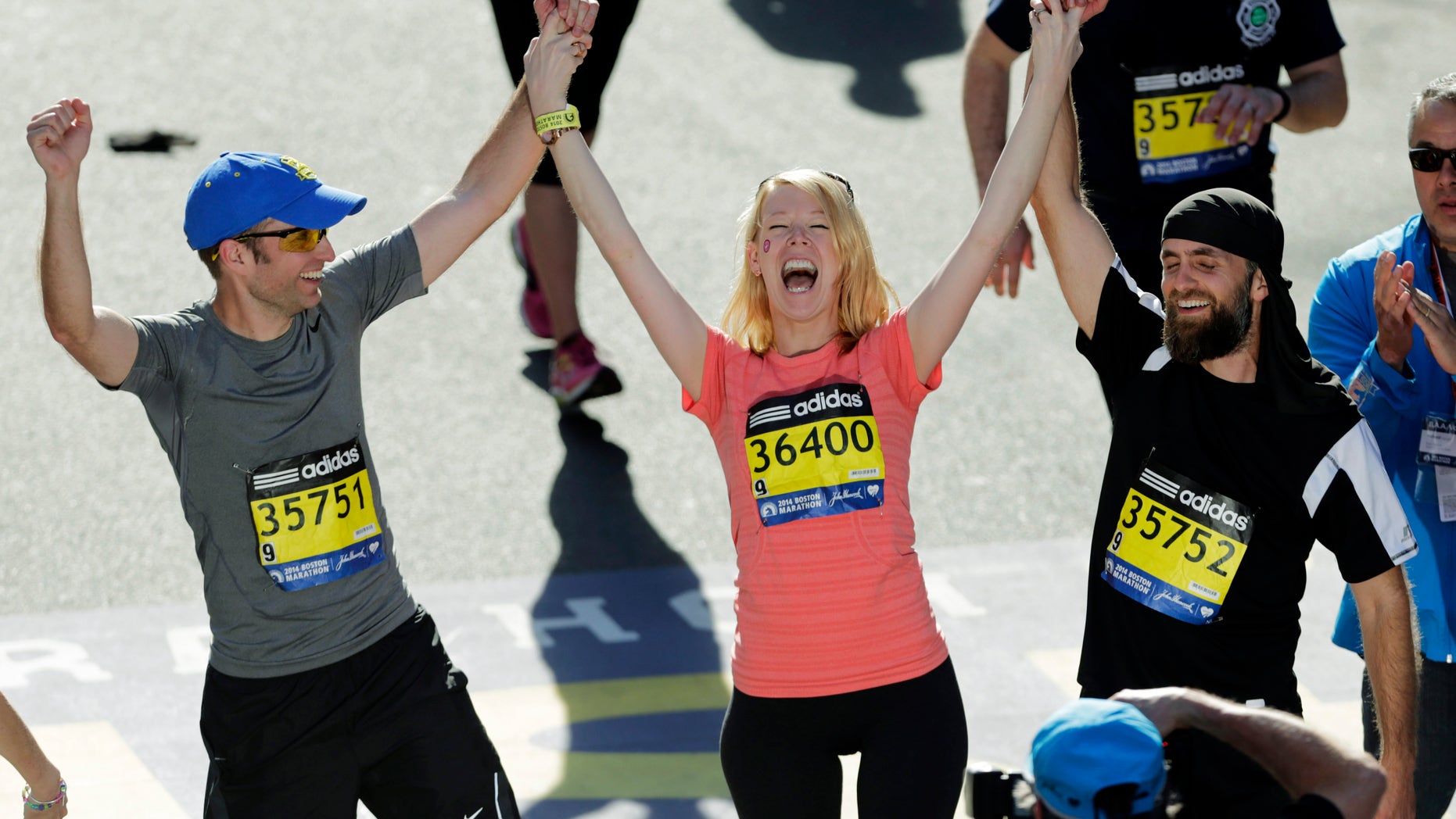 In this April 21, 2014 photo, Timothy Haslet, left, and David Haslet, right, celebrate with their sister Adrianne Haslet-Davis after she completed a short distance of the Boston Marathon course.