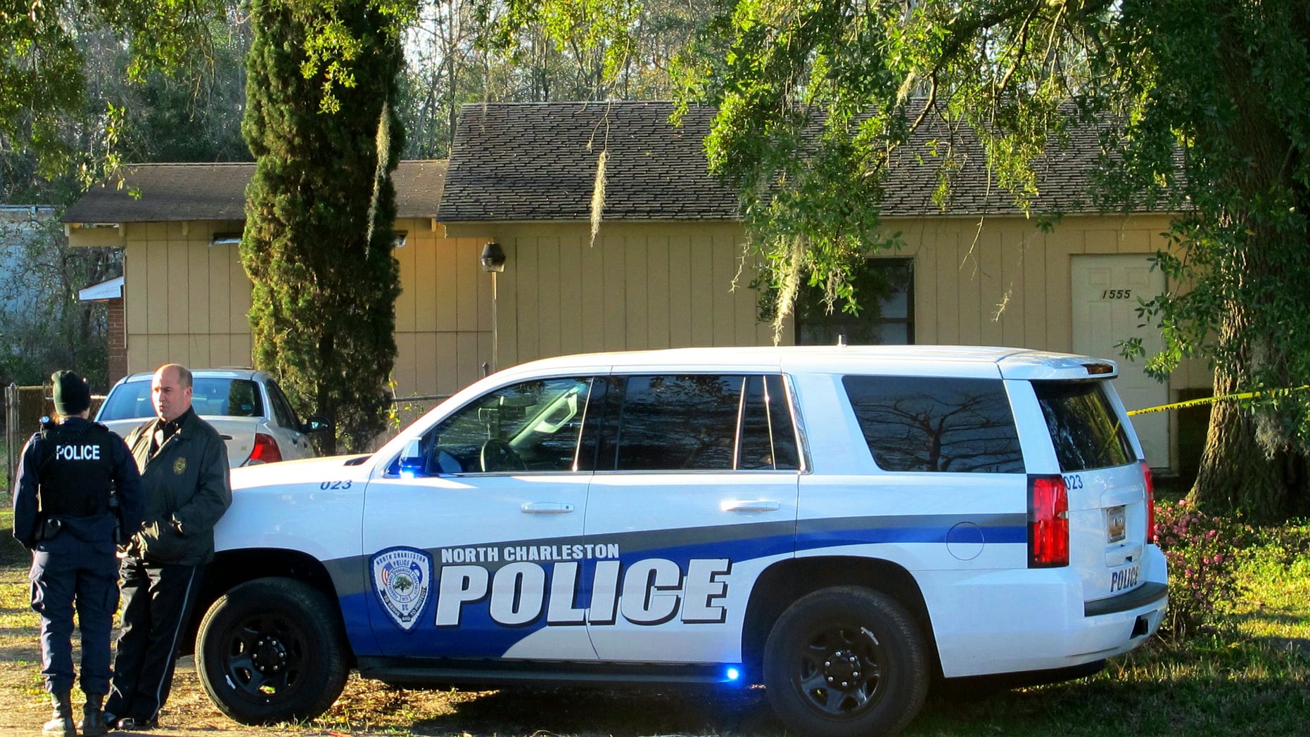 Officers stand outside a house in North Charleston, S.C., on Friday, Feb. 26, 2016, where police say a man died of an apparently self-inflicted gunshot wound after wounding a Berkeley County Sheriff's Deputy earlier in nearby Goose Creek, S.C. Police say the deputy was in serious condition at a hospital after undergoing surgery. (AP Photo/Bruce Smith)