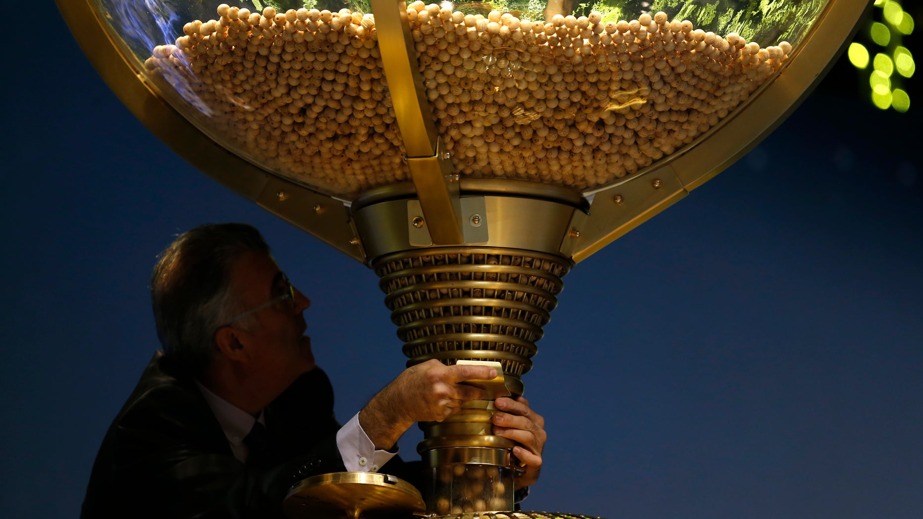 A worker opens a trap-door in a giant drum to let the balls bearing ticket numbers fall before the start of Spain's Christmas lottery.