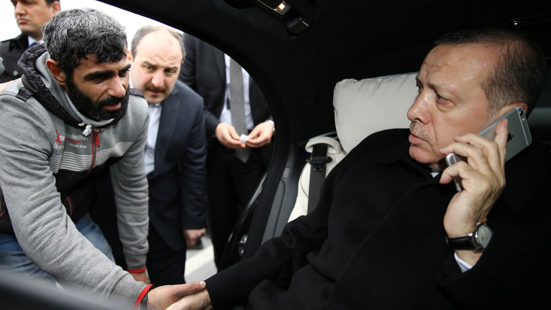 Turkish President Recep Tayyip Erdogan, right, takes Vezir Cakras by hand in Istanbul. Erdogans office says the Turkish president talked Cakras out of jumping off a bridge.
