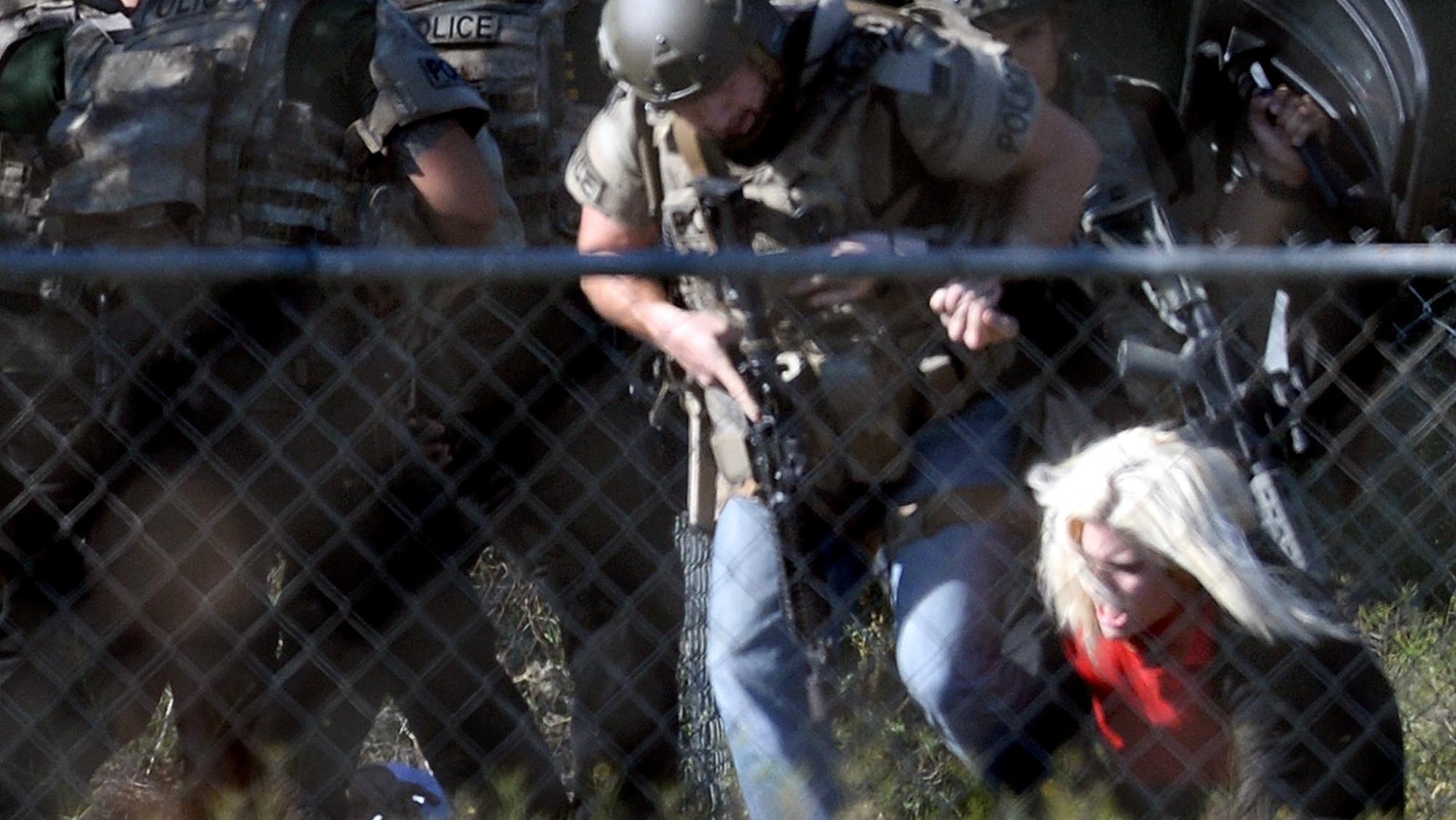 Police officers escort Kristin Bauer after the hostage-taking.
