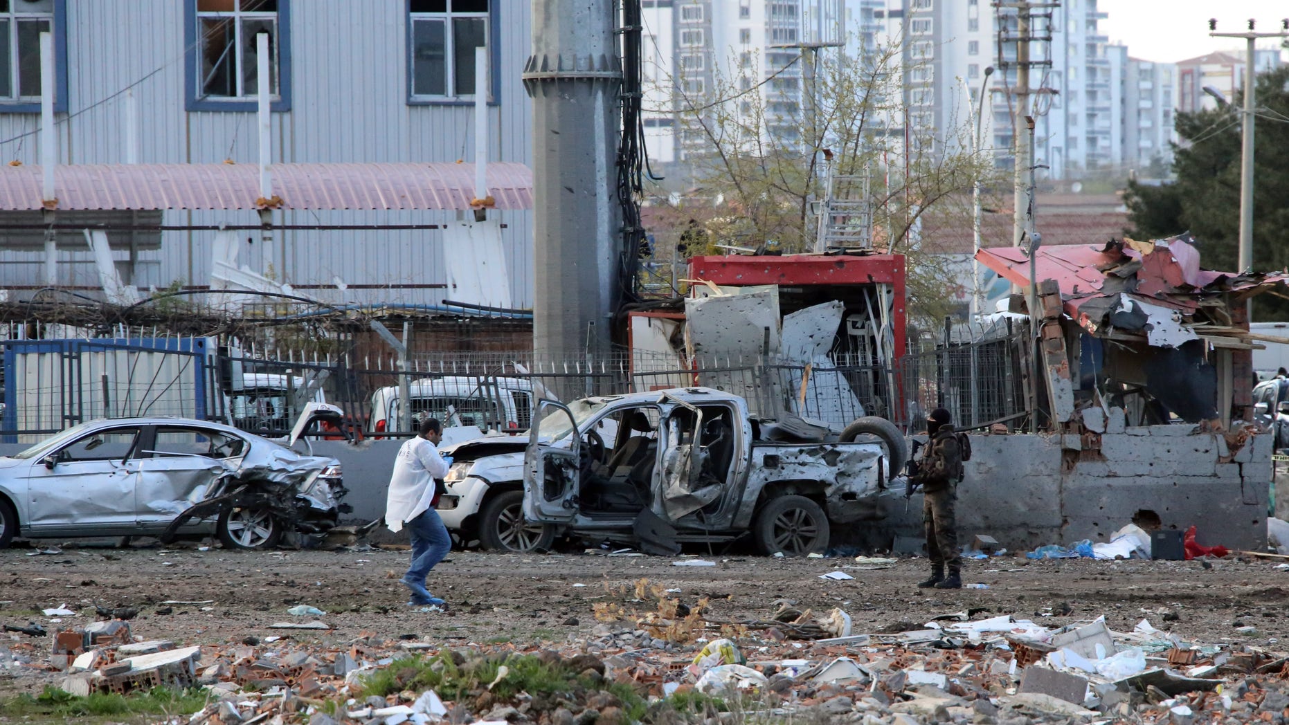 Security and forensic officials work at the site after an explosion caused by a bomb-laden car targeting police in the mainly Kurdish city of Diyarbakir, Turkey, Thursday, March 31, 2016, Turkish news agencies reported. The explosives detonated as a vehicle carrying special forces and riot police passed by, causing many deaths and injuries. (AP Photo/Mahmut Bozarslan)