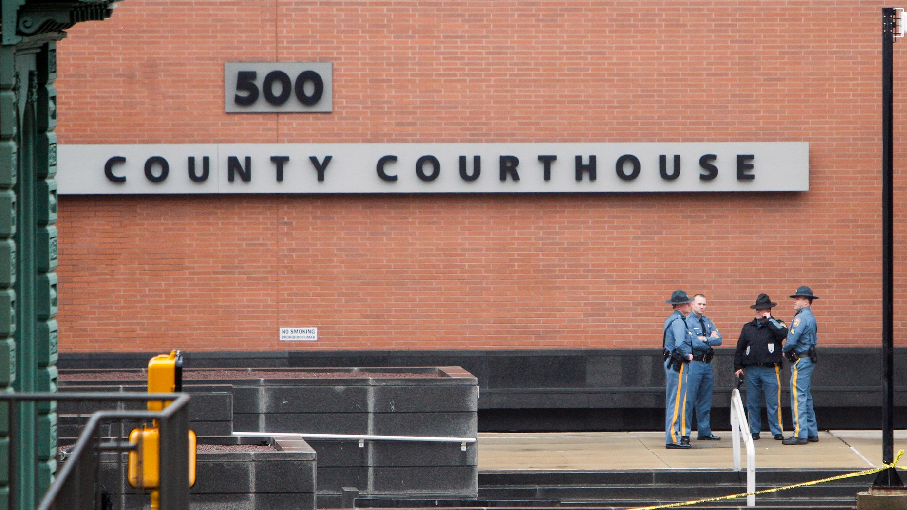 Law enforcement officials and investigators gather outside the New Castle County Courthouse in Wilmington, Del., in 2013.