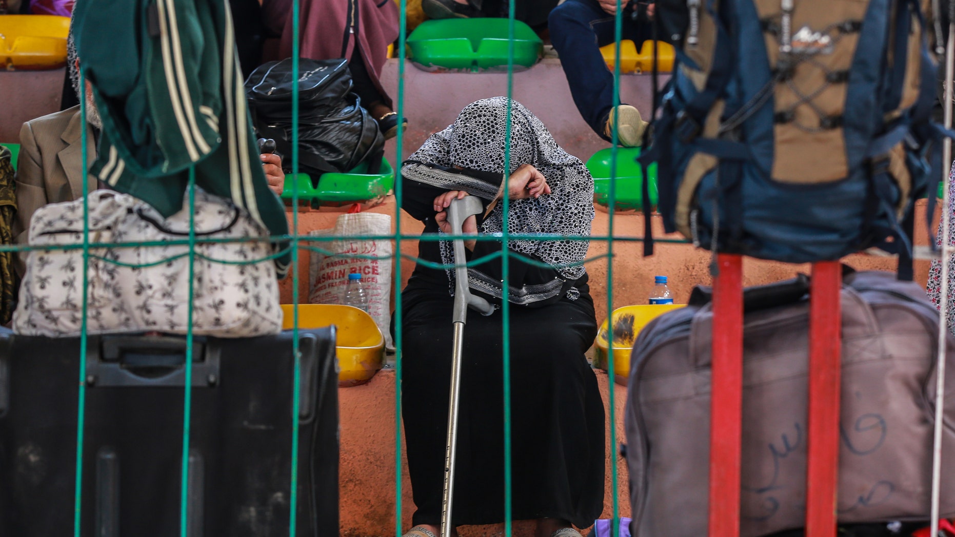 A Palestinian woman waits for a travel permit to cross into Egypt through the Rafah border crossing.