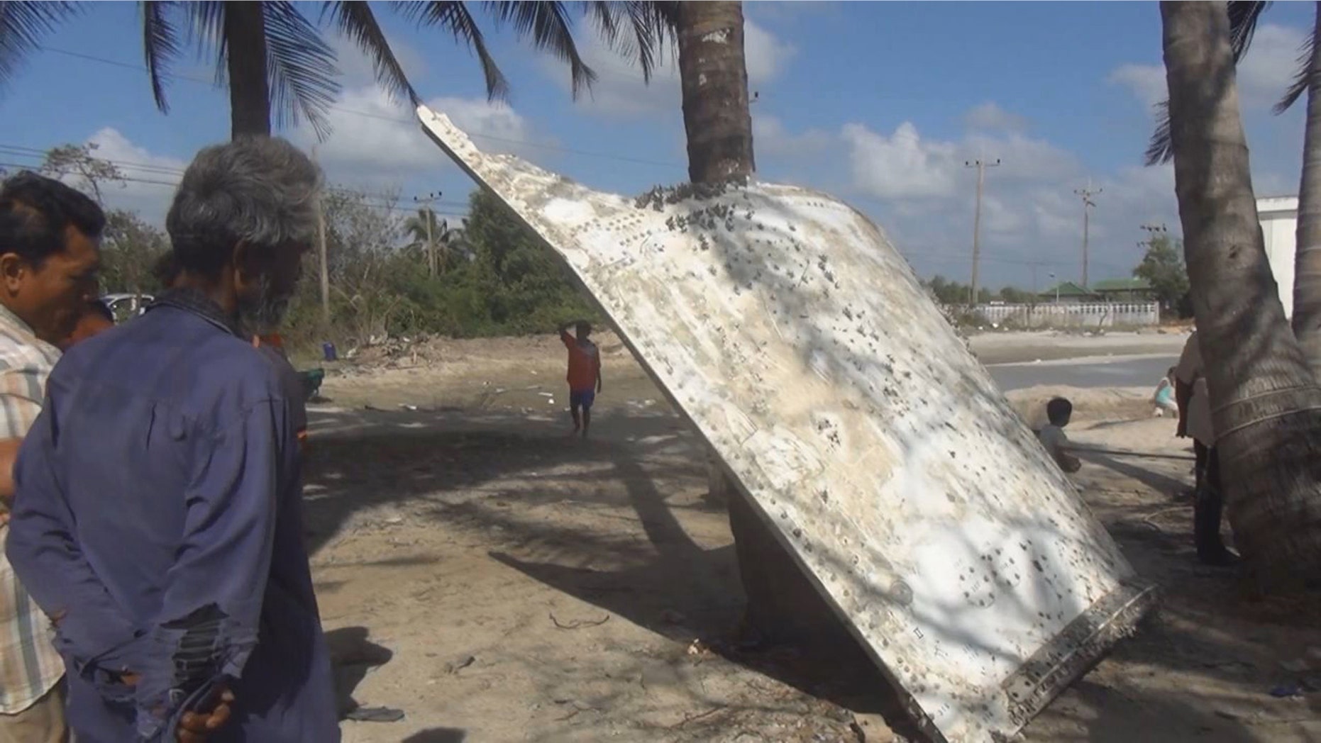 FILE - In this Sunday, Jan. 24, 2016 file photo, Thai people look at a large chunk of metal found on a beach in Nakhon Si Thammarat province, Thailand. A Japanese rocket maker said Monday, Jan. 25 that a large piece of metal that washed up on a beach in Thailand is likely part of a rocket launched by Japan, not a missing Malaysian plane. The discovery of the metal sparked speculation that it might be from Malaysia Airlines Flight 370, which disappeared almost two years ago. (AP Photo/File) THAILAND OUT