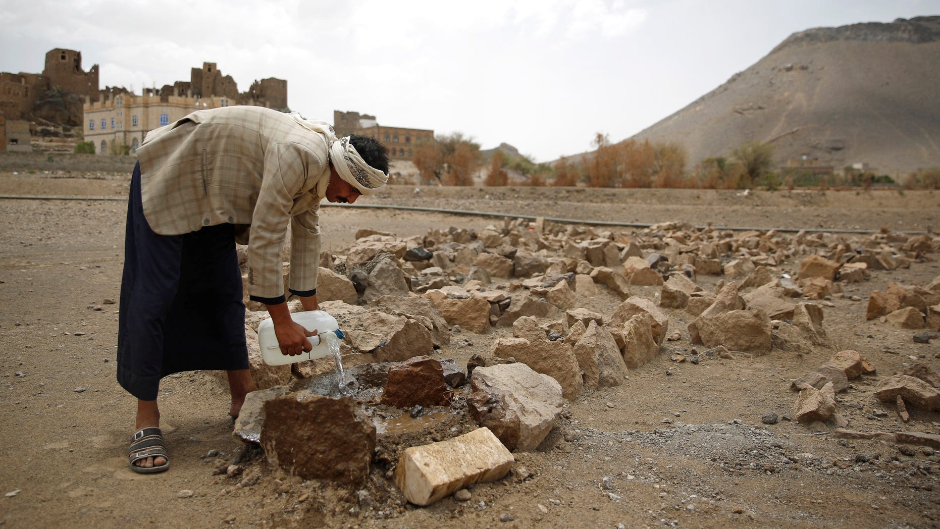 Faisal Ahmed, whose son, Udai Faisal, died of severe acute malnutrition, pours water on his grave in Hazyaz village on the southern outskirts of Sanaa, Yemen.