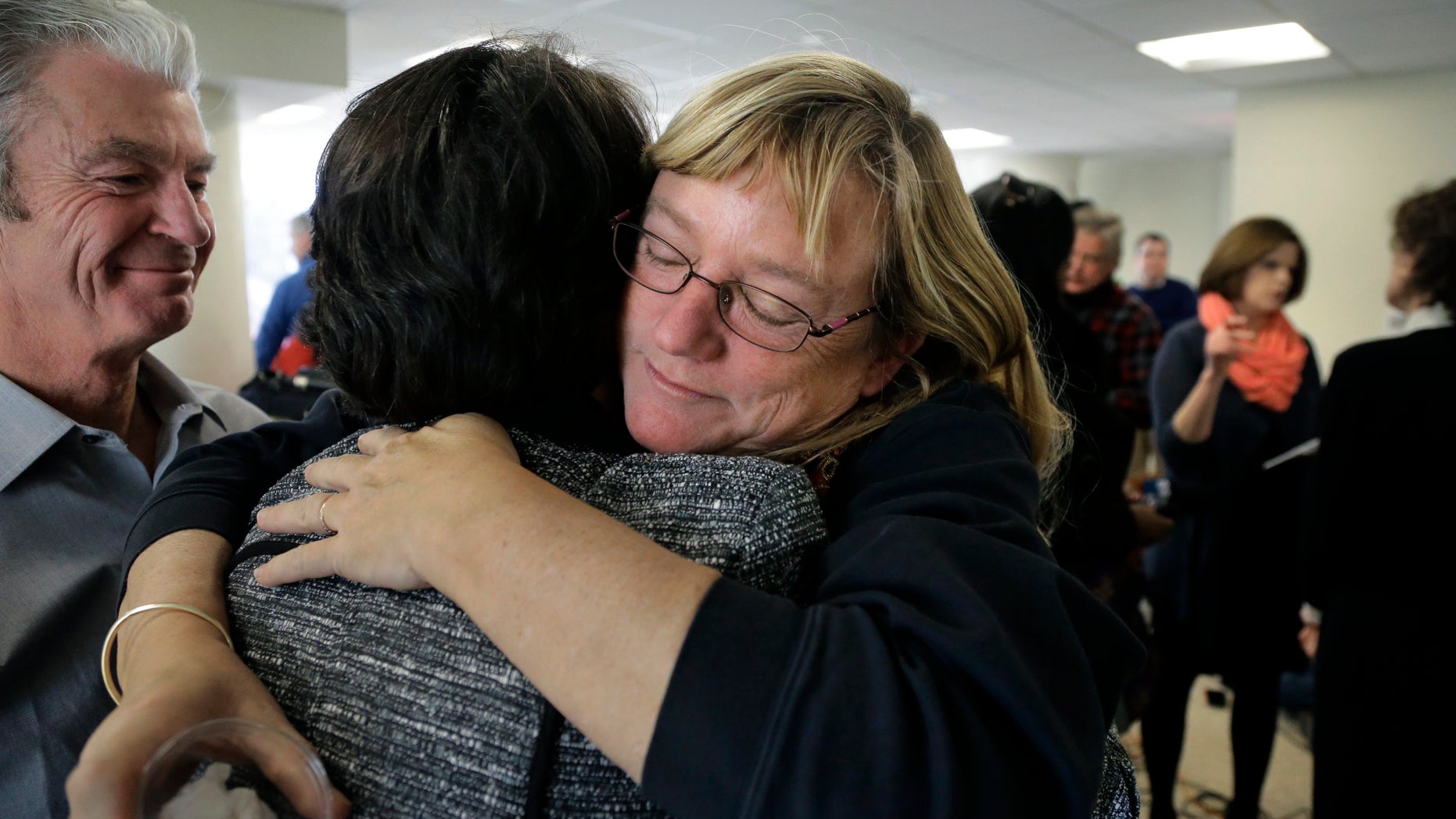 Katie Wales Lovkay, of Granby, Conn., right, who attended St. George's School from 1977-1980, hugs a former classmate, following a news conference, Tuesday, Jan. 5, 2016, in Boston. Former students of the prestigious boarding school in Middletown, R.I., are calling for an independent investigation into sexual abuse that they say spanned three decades and involved at least seven former staff members. Lovkay claims she was sexually assaulted by the school's now deceased athletic trainer. (AP Photo/Steven Senne)