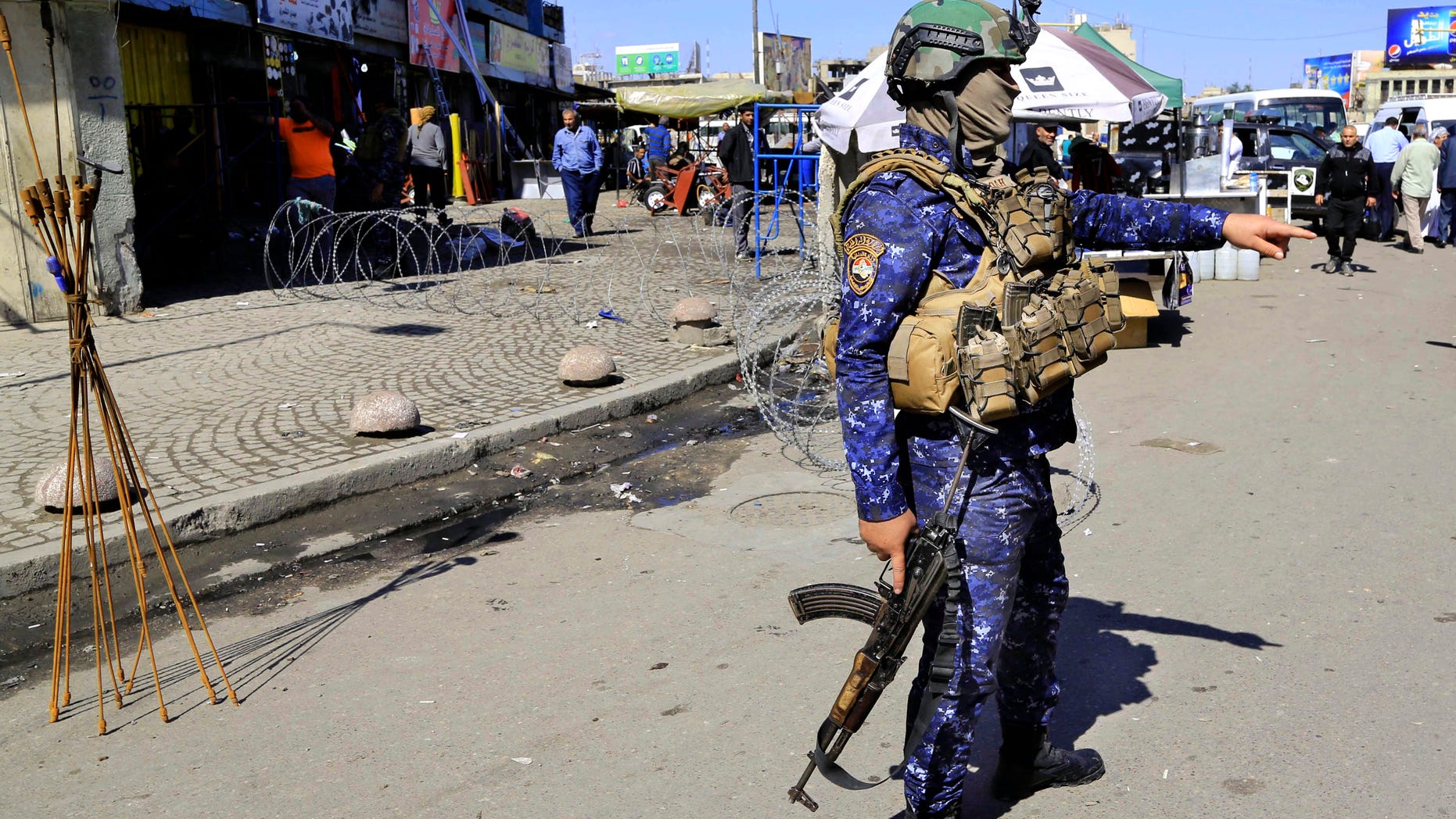 A federal policeman stands guard at the scene of a suicide bombing in Baghdad's Tayaran Square.