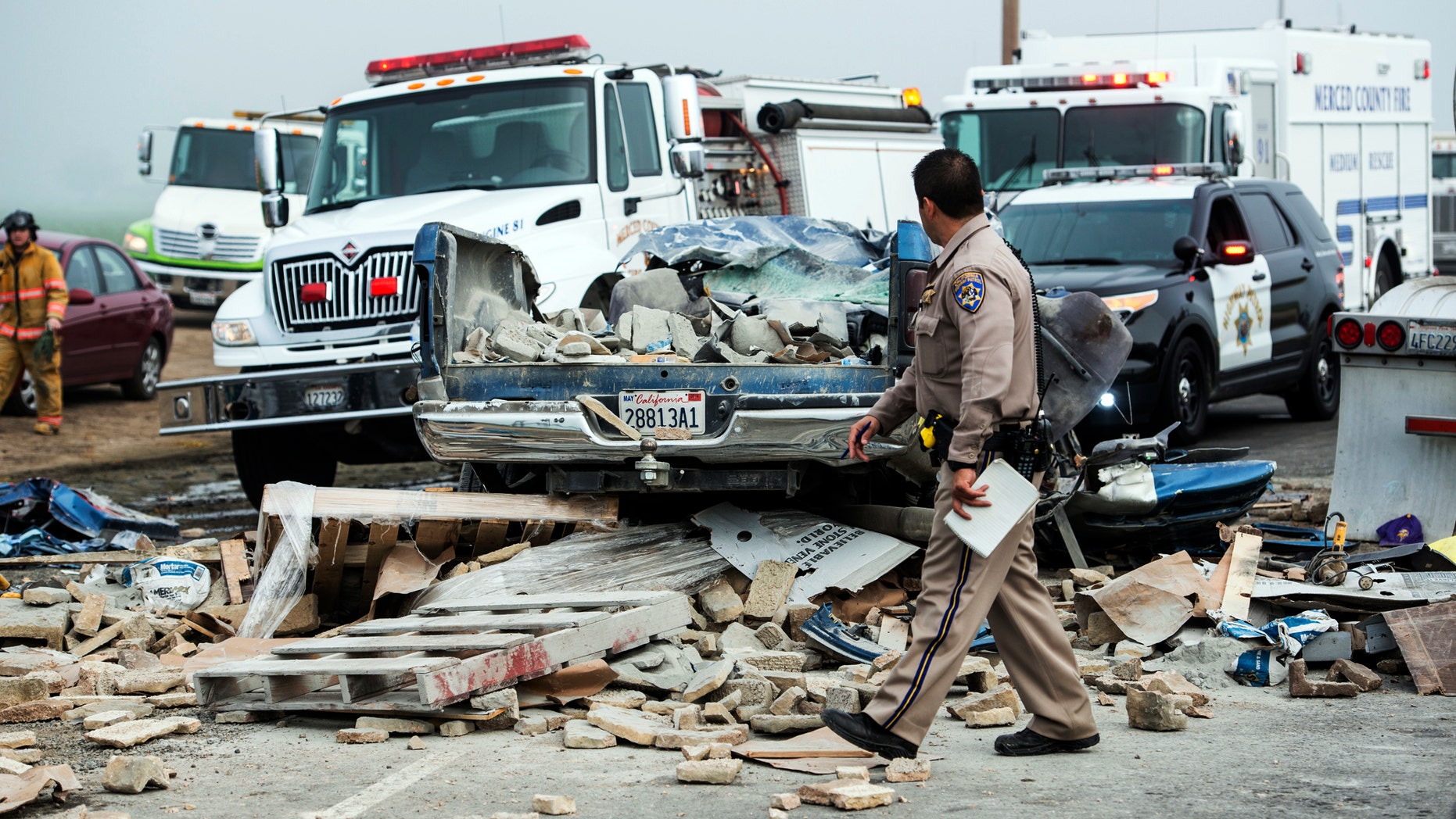 Emergency personnel work at the scene of a crash, one of several separate collisions, on Highway 59 in Merced County, Calif., Saturday, Feb. 13, 2016. The CHP says there was fog on the highway around the time of the crashes, but the cause remains under investigation. (Andrew Kuhn/Merced Sun-Star via AP)