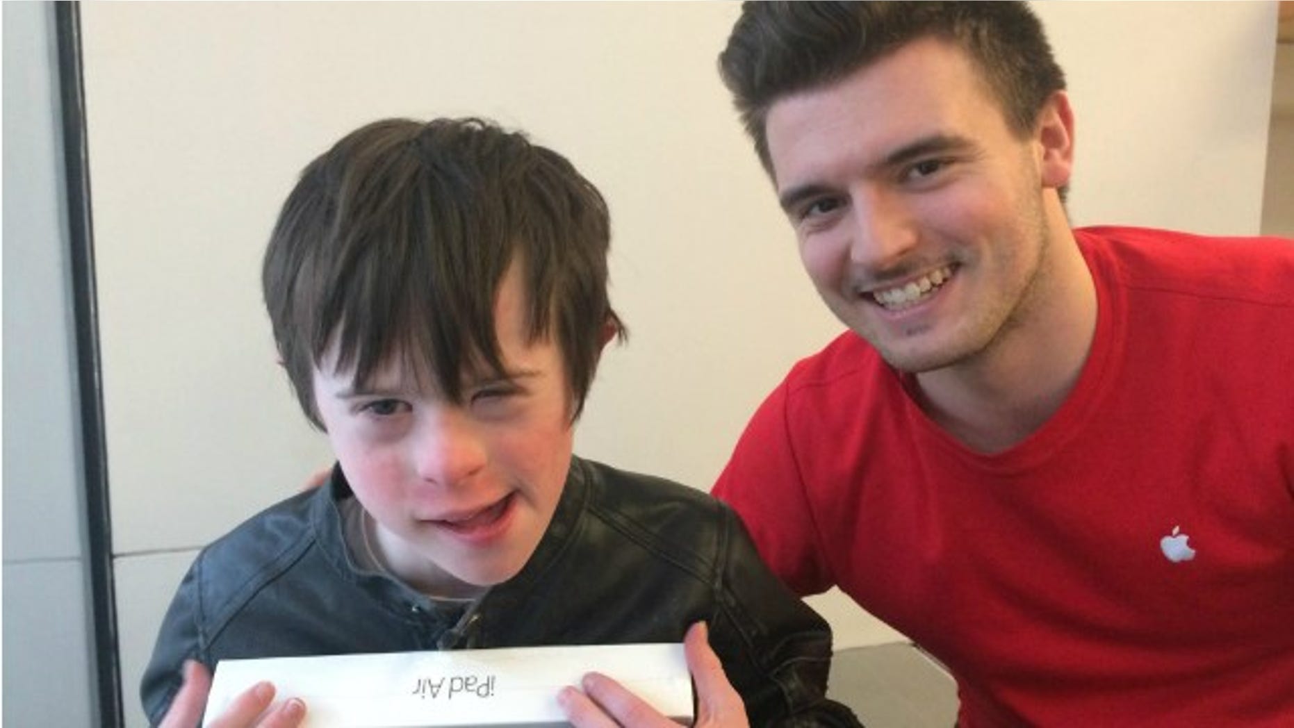 James Rink, 9, poses with Apple Store employee Andrew Wall. Wall helped Rink set up his new iPad on the floor after Rink accidentally ran into a glass wall and fell.