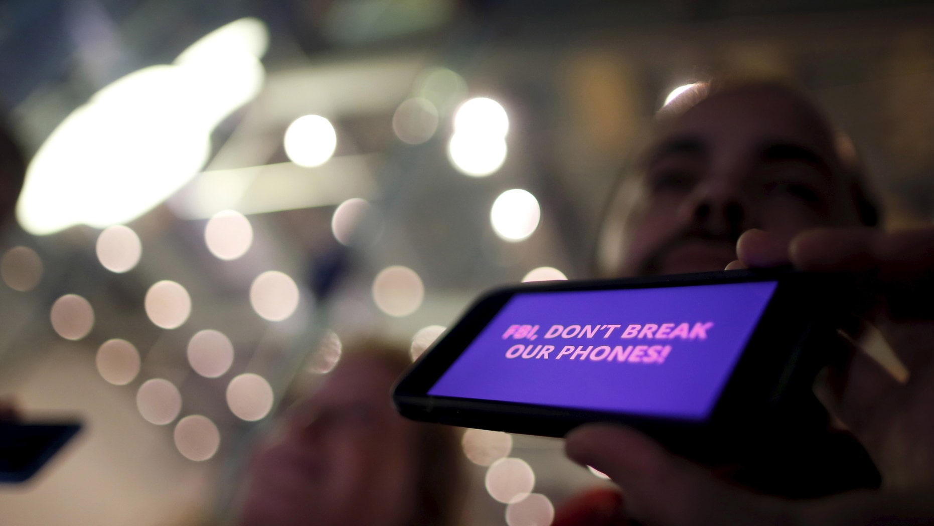 File photo - A man displays a protest message on his iPhone at a small rally in support of Apple's refusal to help the FBI access the cell phone of a gunman involved in the killings of 14 people in San Bernardino, in Santa Monica, California, United States, Feb. 23, 2016. (REUTERS/Lucy Nicholson)