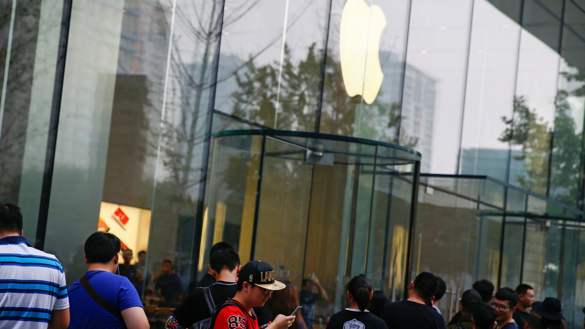 People line up outside an Apple store to purchase the new iPhone 7, in Beijing, China Sept. 16, 2016. (REUTERS/Thomas Peter)