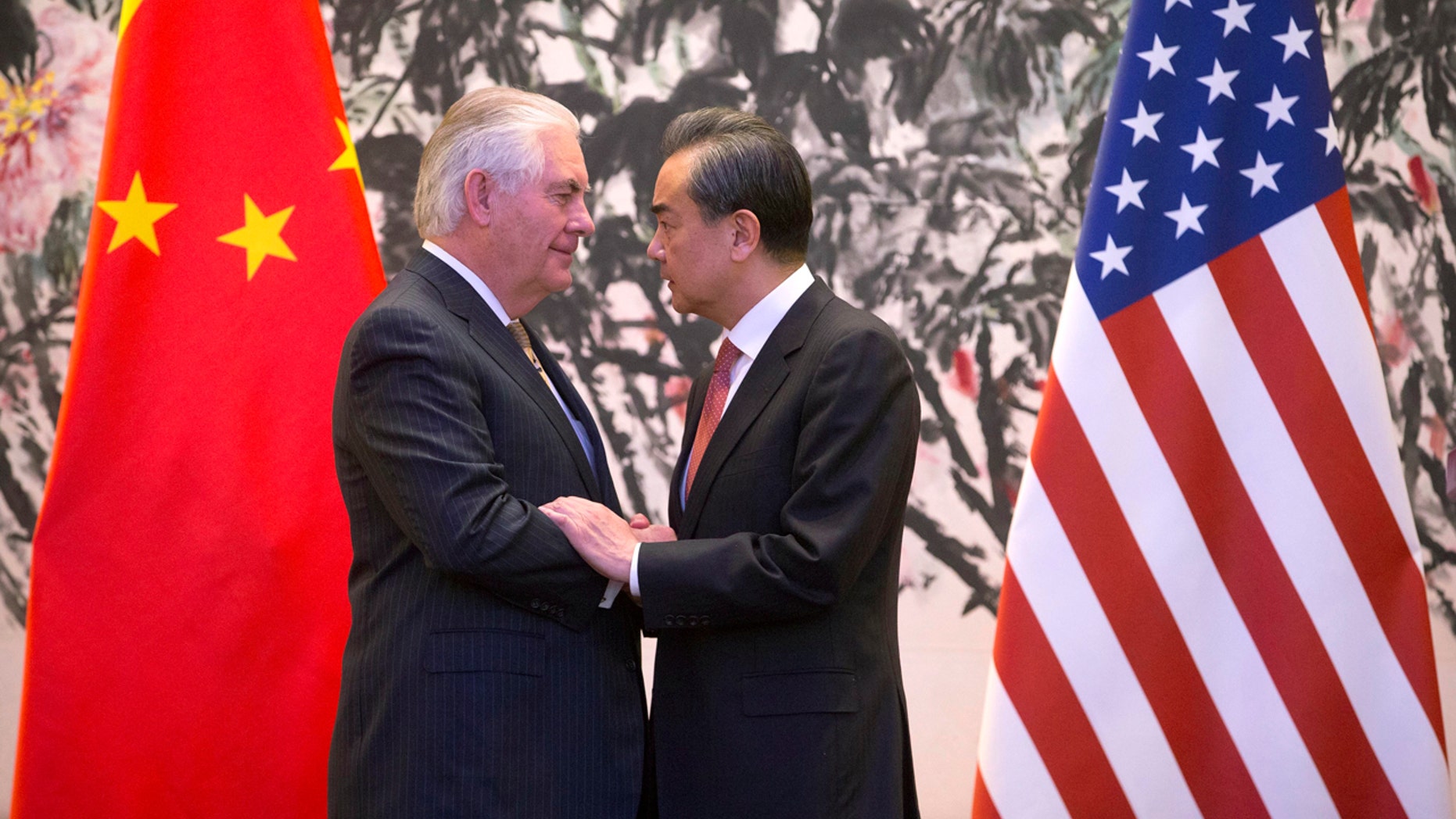 U.S. Secretary of State Rex Tillerson, left, and Chinese Foreign Minister Wang Yi stare at each other as they shake hands at the end of a joint press conference following their meeting at the Diaoyutai State Guesthouse in Beijing, China, Saturday, March 18, 2017.