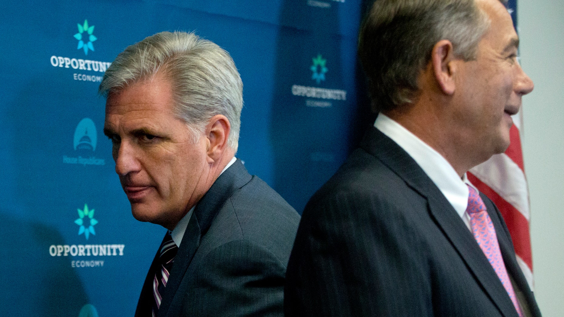 Sept. 29, 2015: House Majority Leader Kevin McCarthy of Calif., left, squeezes behind outgoing House Speaker John Boehner of Ohio at the start of a news conference on Capitol Hill in Washington.