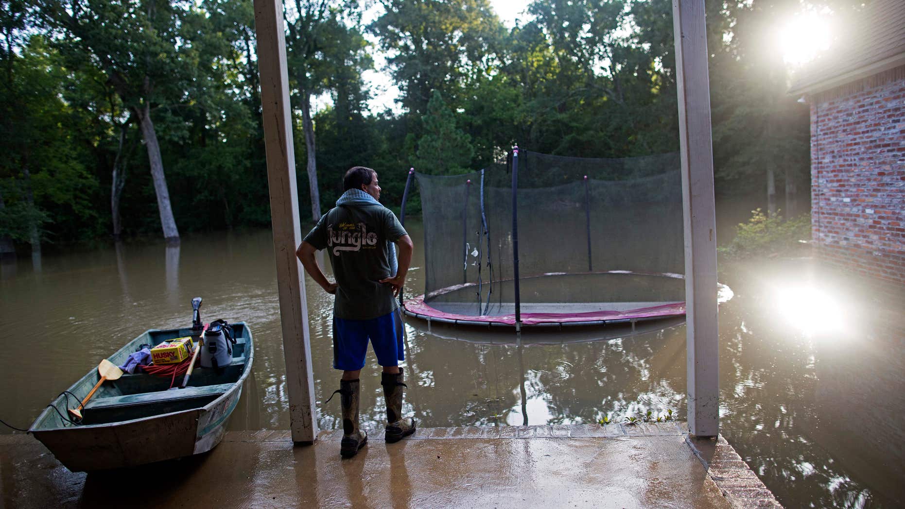 David Key looks at the back yard of his flooded home in Prairieville.