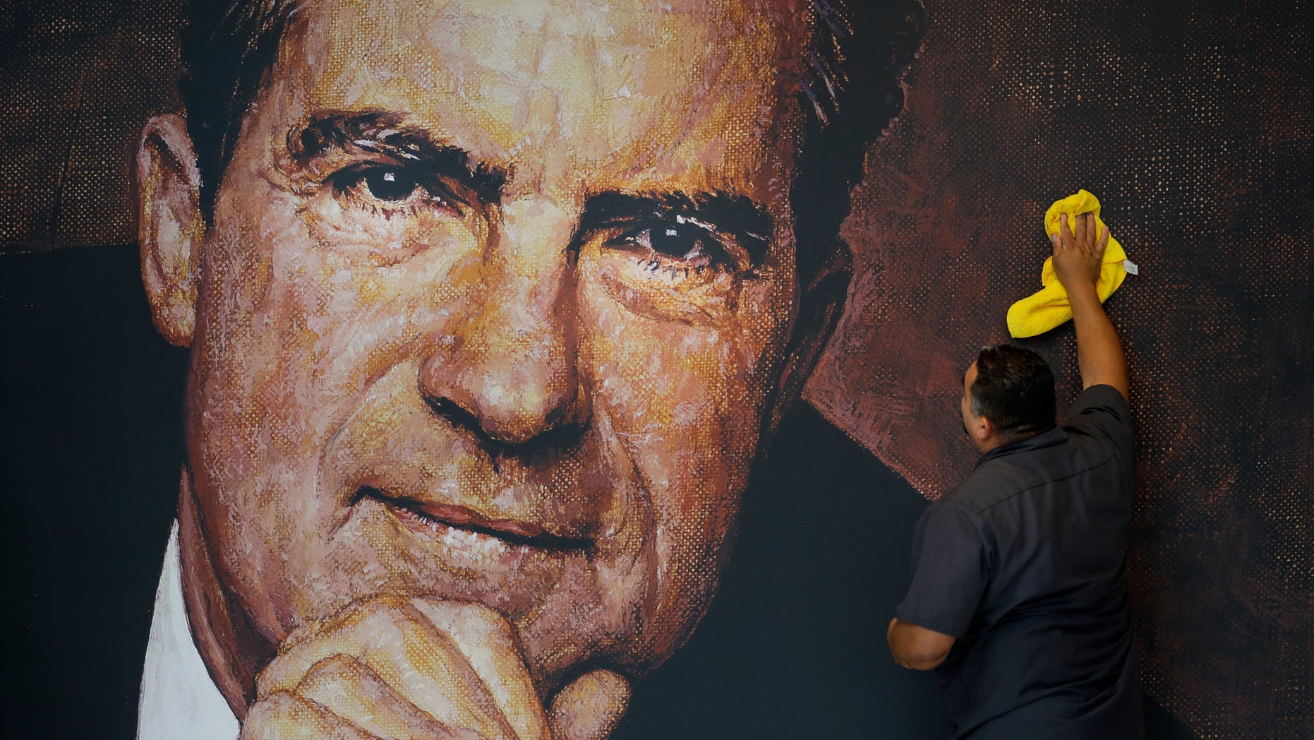Oct. 5, 2016: Tayron Santos cleans the newly-installed wall mural of former President Richard Nixon in the lobby area of the Richard Nixon Presidential Library and Museum in Yorba Linda, Calif.