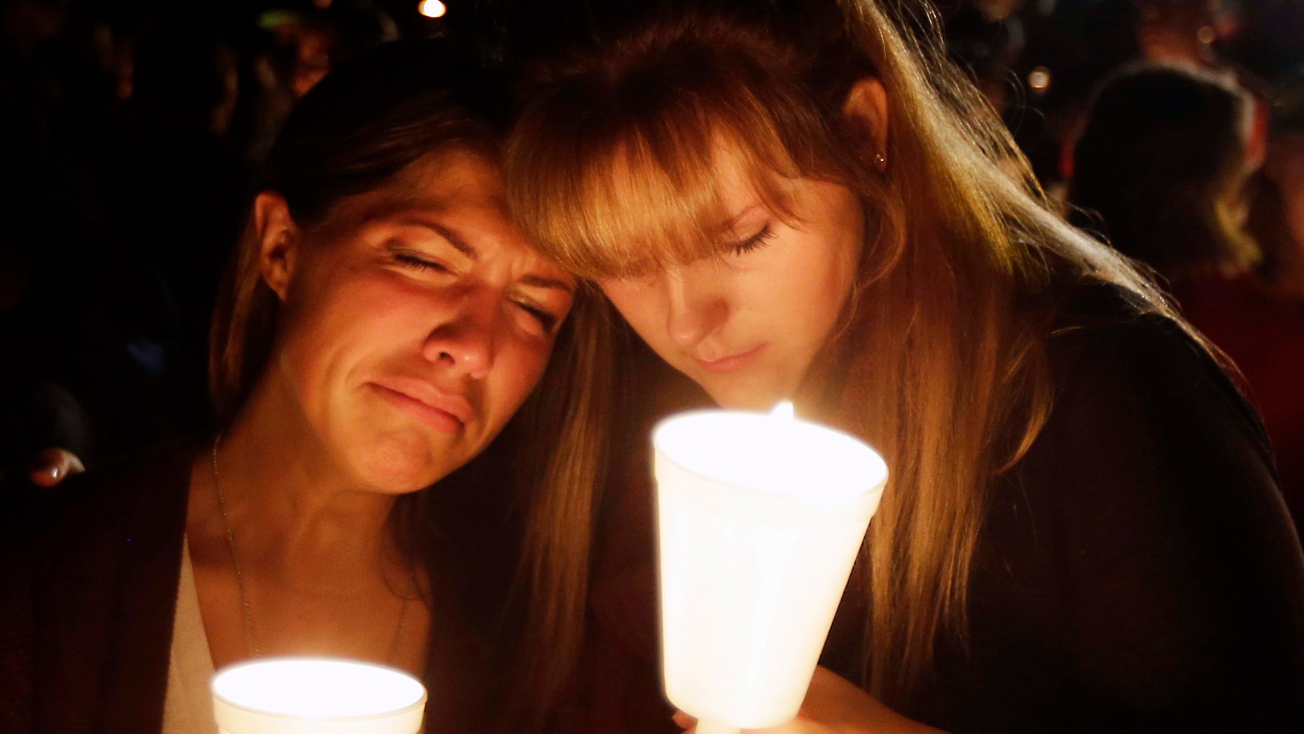 Kristen Sterner, left, and Carrissa Welding, both students at Umpqua Community College, embrace each other during a candlelight vigil for those killed during a shooting at the college, Thursday, Oct. 1, 2015, in Roseburg, Ore. (AP Photo/Rich Pedroncelli)