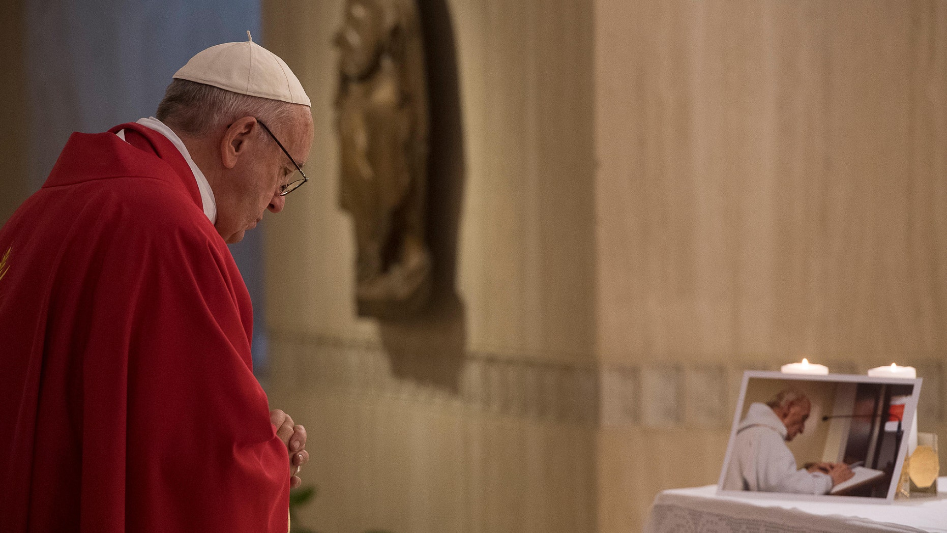 Pope Francis prays in front of a picture of Rev. Jacques Hamel on Wednesday.