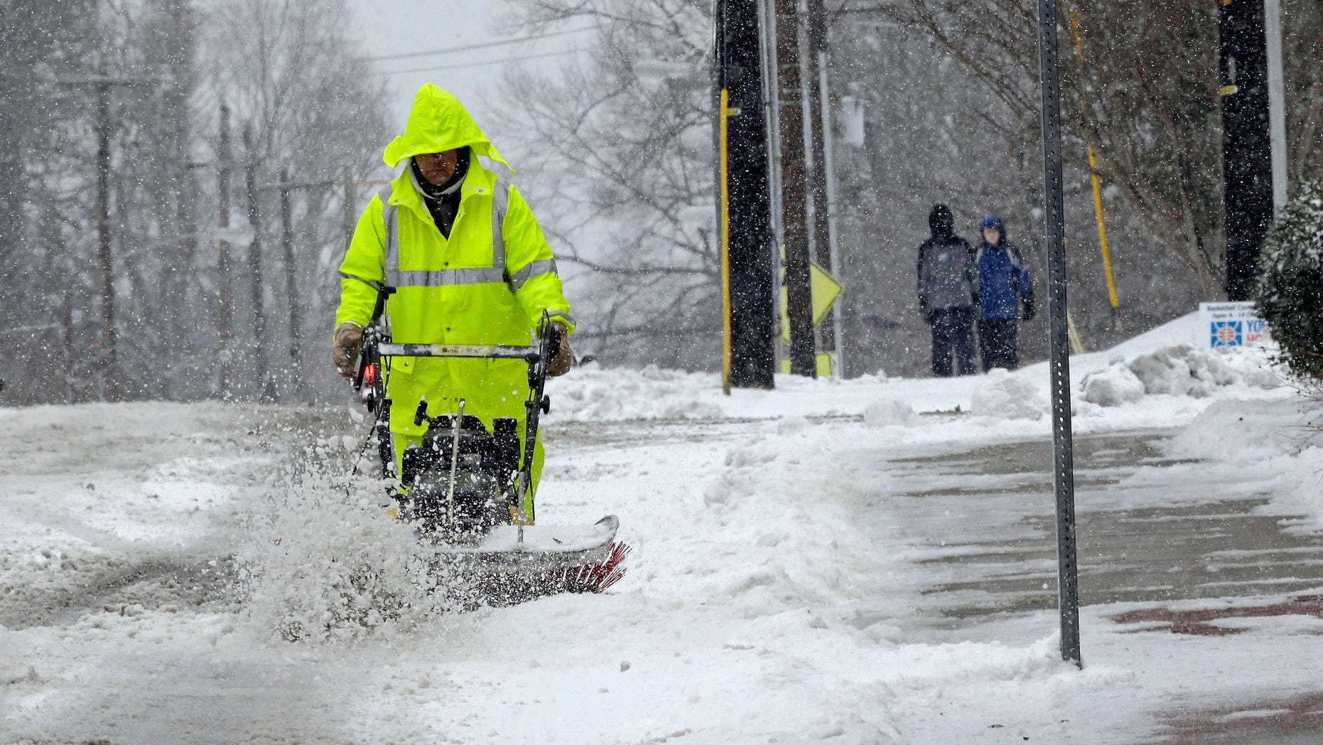 A city worker removes snow from a crosswalk as a winter storm blankets the area in Carrboro, N.C., Saturday, Jan. 7, 2017. Snow and sleet pounded a large swath of the East Coast on Saturday, coating roads with ice and causing hundreds of crashes (AP Photo/Gerry Broome)
