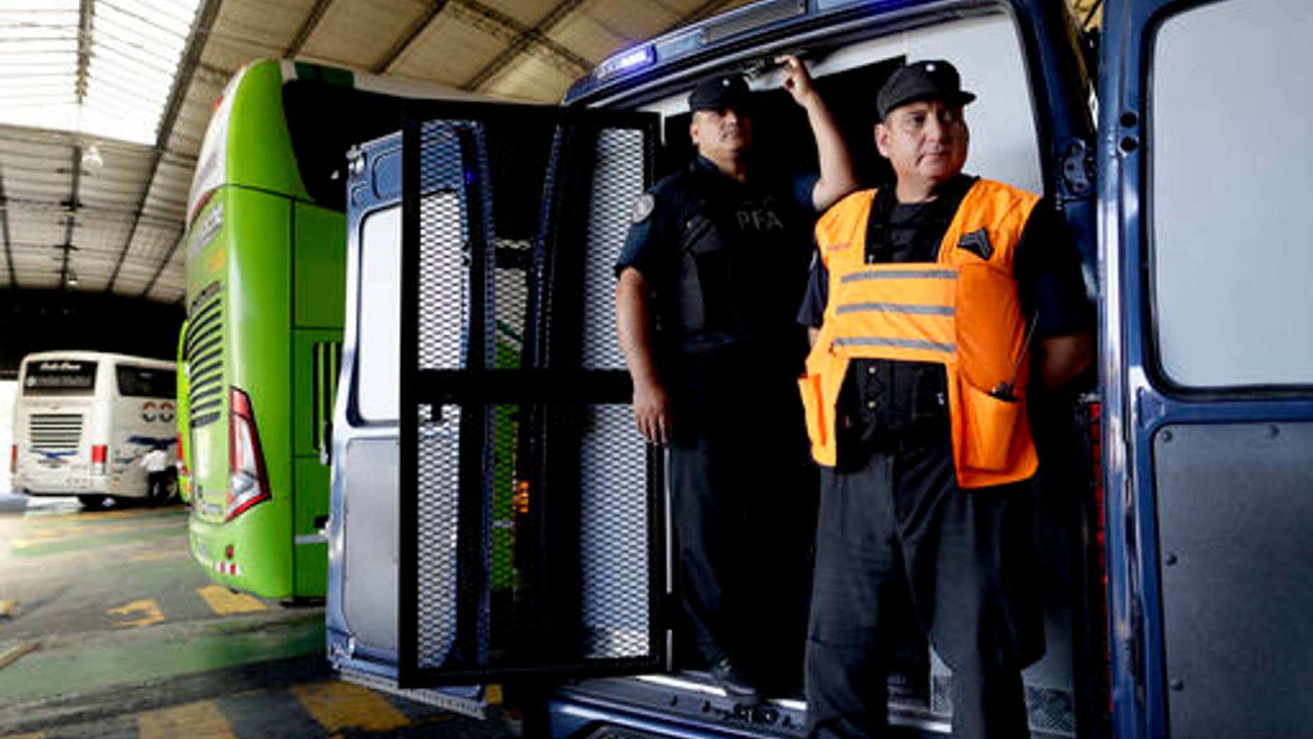 Police guard vehicle holding bags confiscated at a bus station on the outskirts of Buenos Aires, Jan. 27, 2017