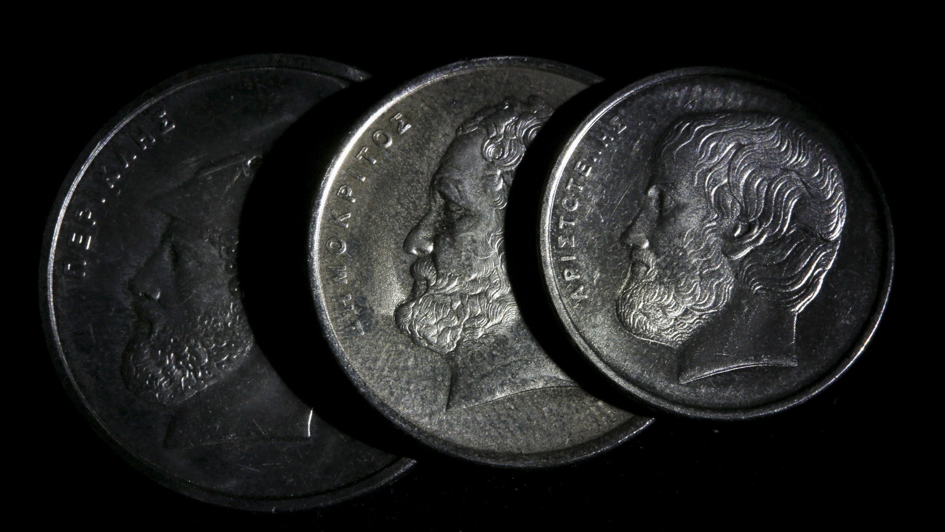 File photo - Ancient Greek philosopher Aristotle (L), philosopher and scientist Democritus (C) and Athenian politician and general Pericles are depicted on Greek Drachma coins in this picture illustration taken in Athens March 22, 2015. (REUTERS/Yannis Behrakis)