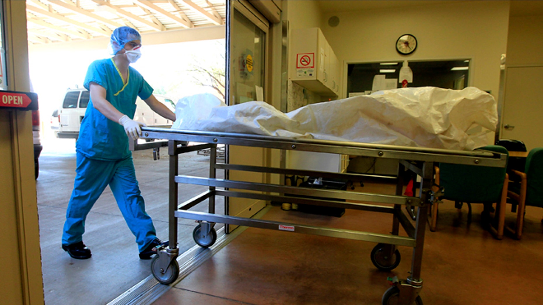 Aug. 10, 2012: In this photo, a morgue staff member brings in the body of a suspected illegal immigrant found in the Arizona desert, at the Pima County morgue in Tucson, Ariz.